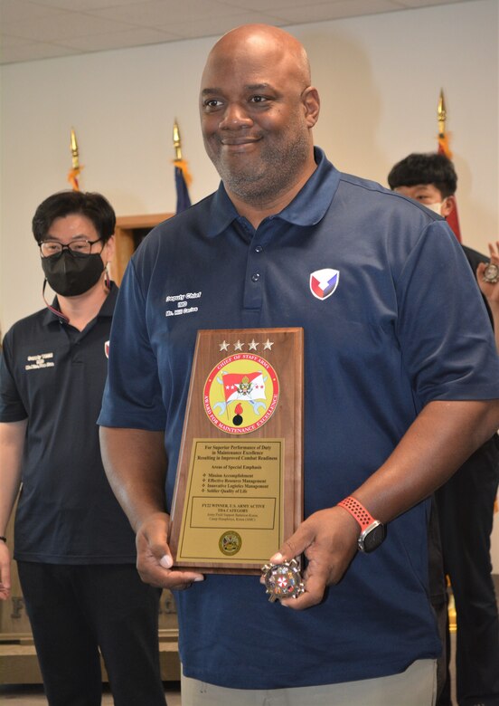 Carlos Hill, chief, Maintenance Division, Army Field Support Battalion–Korea, displays the Fiscal Year 2022 Army Award for Maintenance Excellence plaque following the presentation ceremony at Camp Humphreys, South Korea, Dec. 8, 2022.