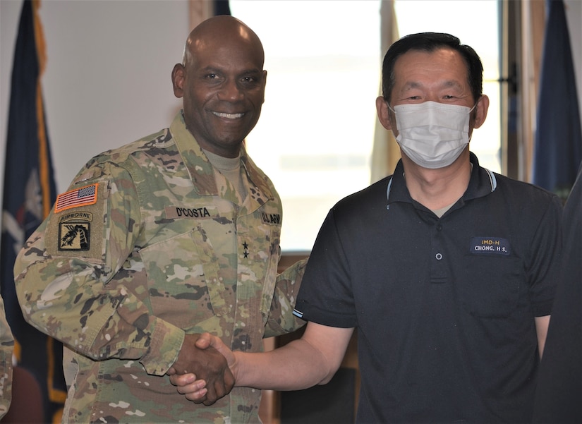 Maj. Gen. Joseph D’costa, deputy commanding general – sustainment, Eighth Army, congratulates Chong, Hak Song, mechanic, Maintenance Division, Army Field Support Battalion–Korea, during the Fiscal Year 2022 Army Award for Maintenance Excellence Presentation Ceremony at Camp Humphreys, South Korea, Dec. 8, 2022.