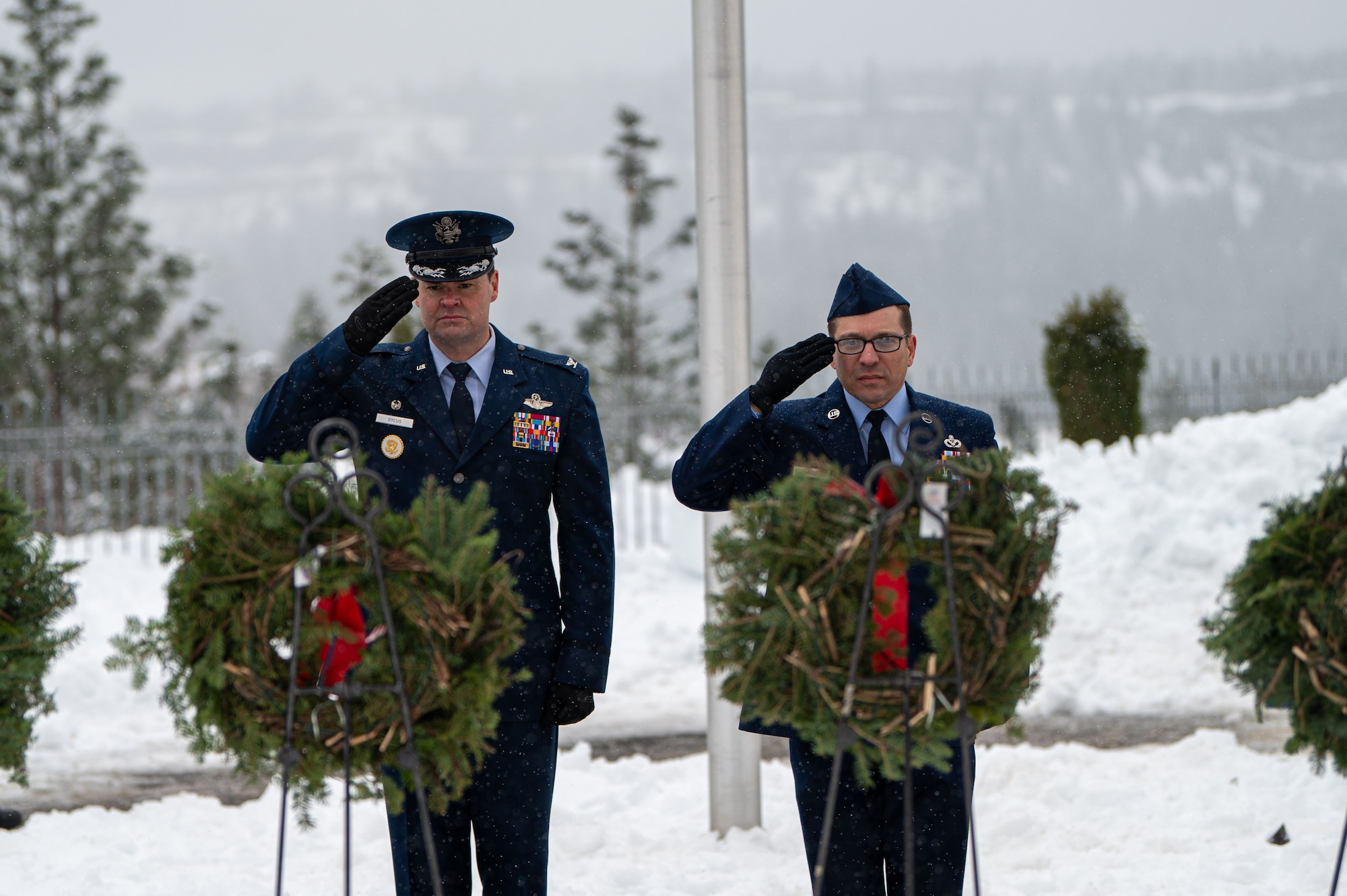 U.S. Air Force Col. Chesley Dycus (left) and Chief Master Sgt. William Arcuri (right), 92nd Air Refueling Wing commander and command chief, render a salute during a Wreaths Across America ceremony at Fort Wright Cemetery in Spokane, Washington, Dec. 17, 2022. The event has participating members place wreaths on fallen service members’ gravestones and displays ceremonial wreaths for each branch of service. (U.S. Air Force photo by Airman 1st Class Stassney Davis)