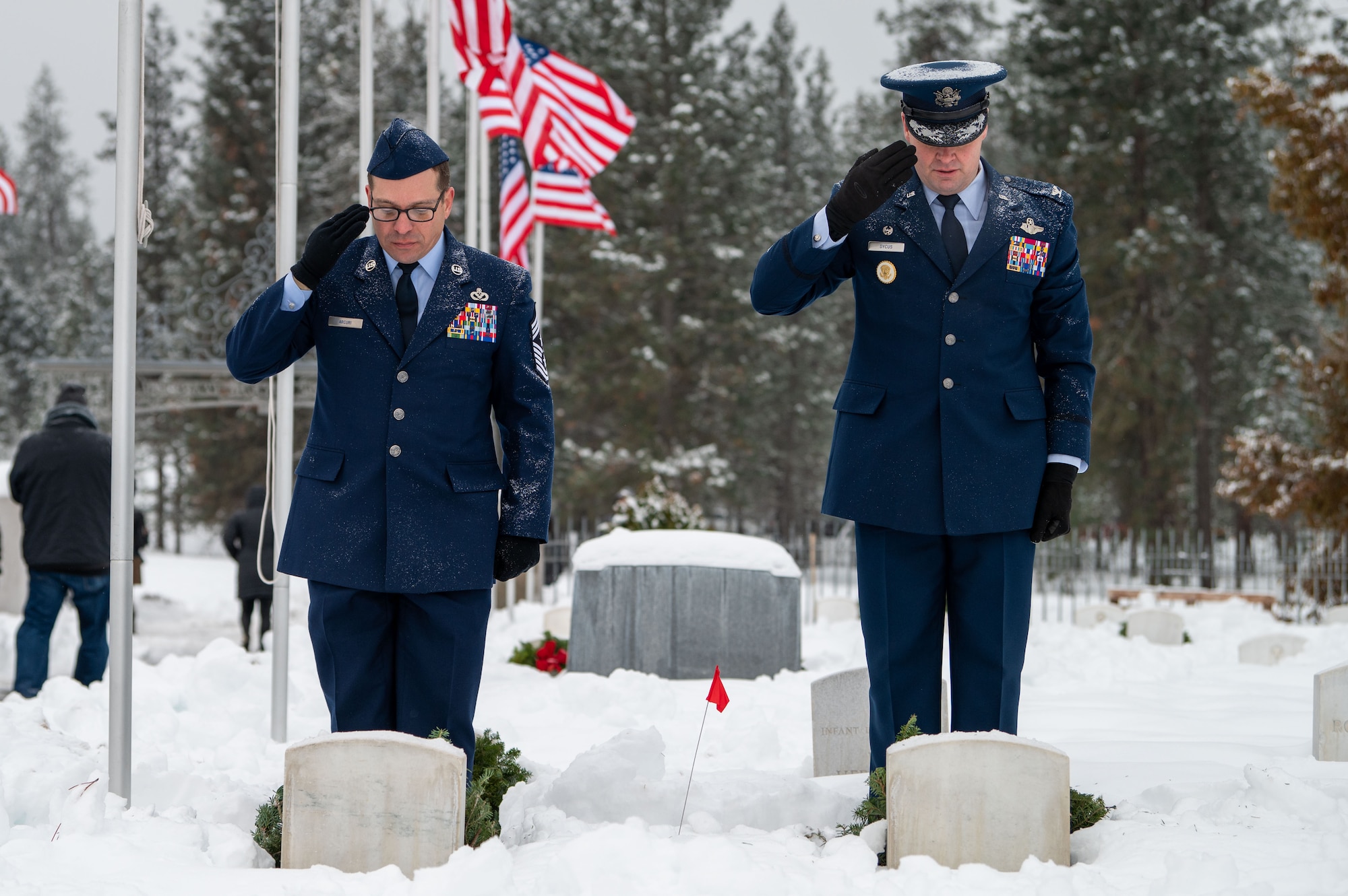 U.S. Air Force Chief Master Sgt. William Arcuri (left) and Col. Chesley Dycus (right), 92nd Air Refueling Wing command chief and commander, render a salute during a Wreaths Across America ceremony at Fort Wright Cemetery in Spokane, Washington, Dec. 17, 2022. The event has participating members place wreaths on fallen service members’ gravestones and displays ceremonial wreaths for each branch of service. (U.S. Air Force photo by Airman 1st Class Stassney Davis)