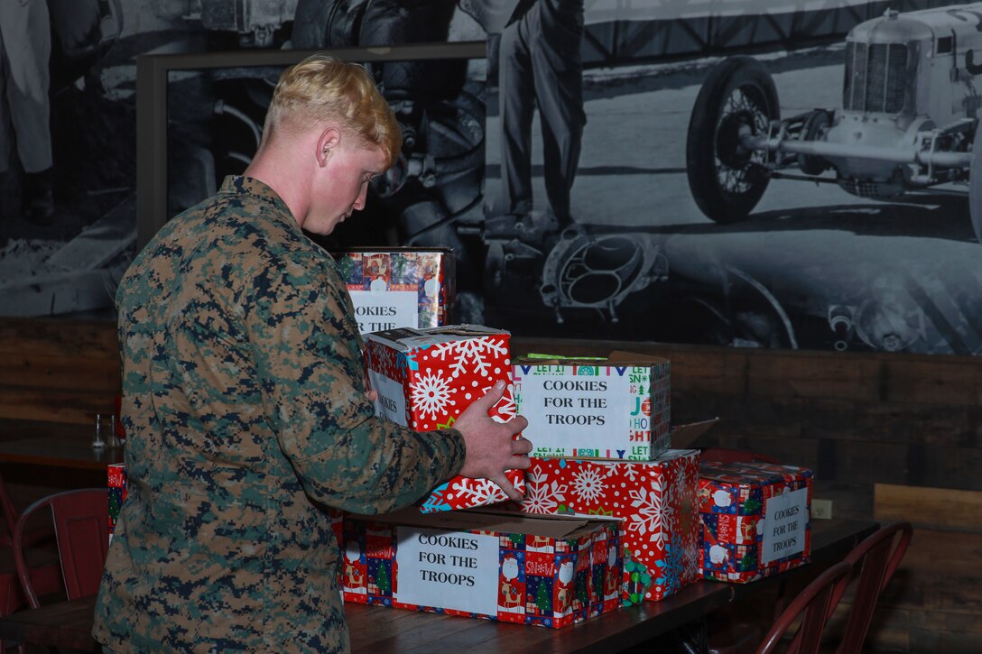 U.S. Marine Corps Cpl. John Golden, a calibration and repair technician with Marine Aviation Logistics Squadron 14, grabs a box of cookies during the Cookies for Troops event hosted by Carteret County at Marine Corps Air Station Cherry Point, North Carolina, Dec. 16, 2022. Carteret County hosts this annual event to thank service members for their sacrifice and service during the holiday season. (U.S Marine Corps photo by Lance Cpl. Jade Farrington)