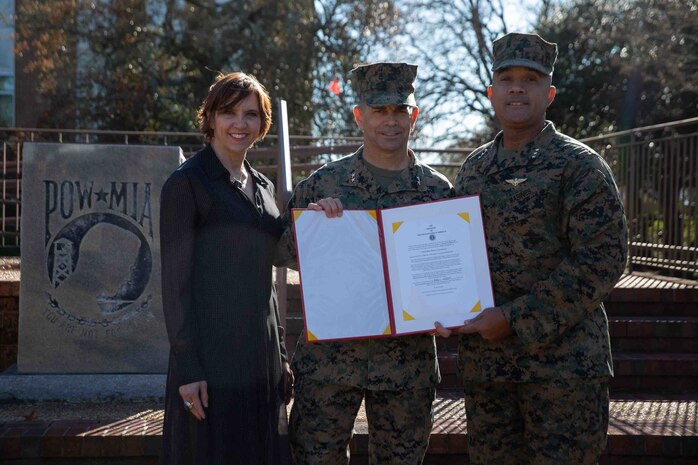 U.S. Marine Corps Lt. Gen. Brian W. Cavanaugh, the commanding general for Fleet Marine Force, Atlantic (FMFLANT), Marine Forces Command (MARFORCOM), Marine Forces Northern Command (MARFOR NORTHCOM), Brig. Gen. John F. Kelliher III, the deputy commanding general for FMFLANT, MARFORCOM, MARFOR NORTHCOM, and his wife Mrs. Susan Kelliher hold award given during a promotion ceremony at Naval Support Activity Hampton Roads, Virginia, Dec. 16, 2022. During his 30 years of service he accumulated more than 4,500 mishap-free flight hours in seven different aircrafts. General officers are nominated for promotion by the President and confirmed by the Senate. As a newly promoted Maj. Gen., Kelliher’s responsibilities include overseeing the staff's planning and coordination of missions. (U.S. Marine Corps photo by Lance Cpl. Jack Chen)