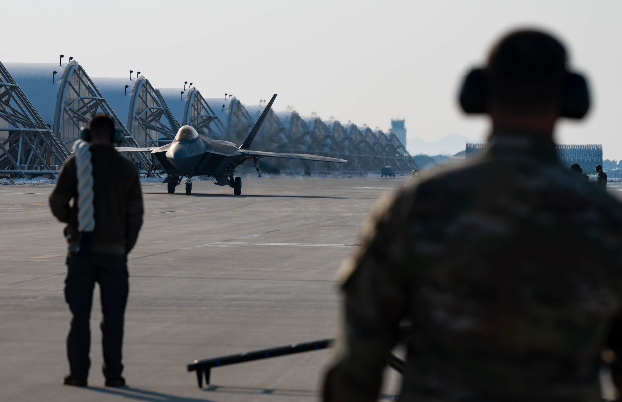 An F-2 Raptor taxi's towards Airmen.