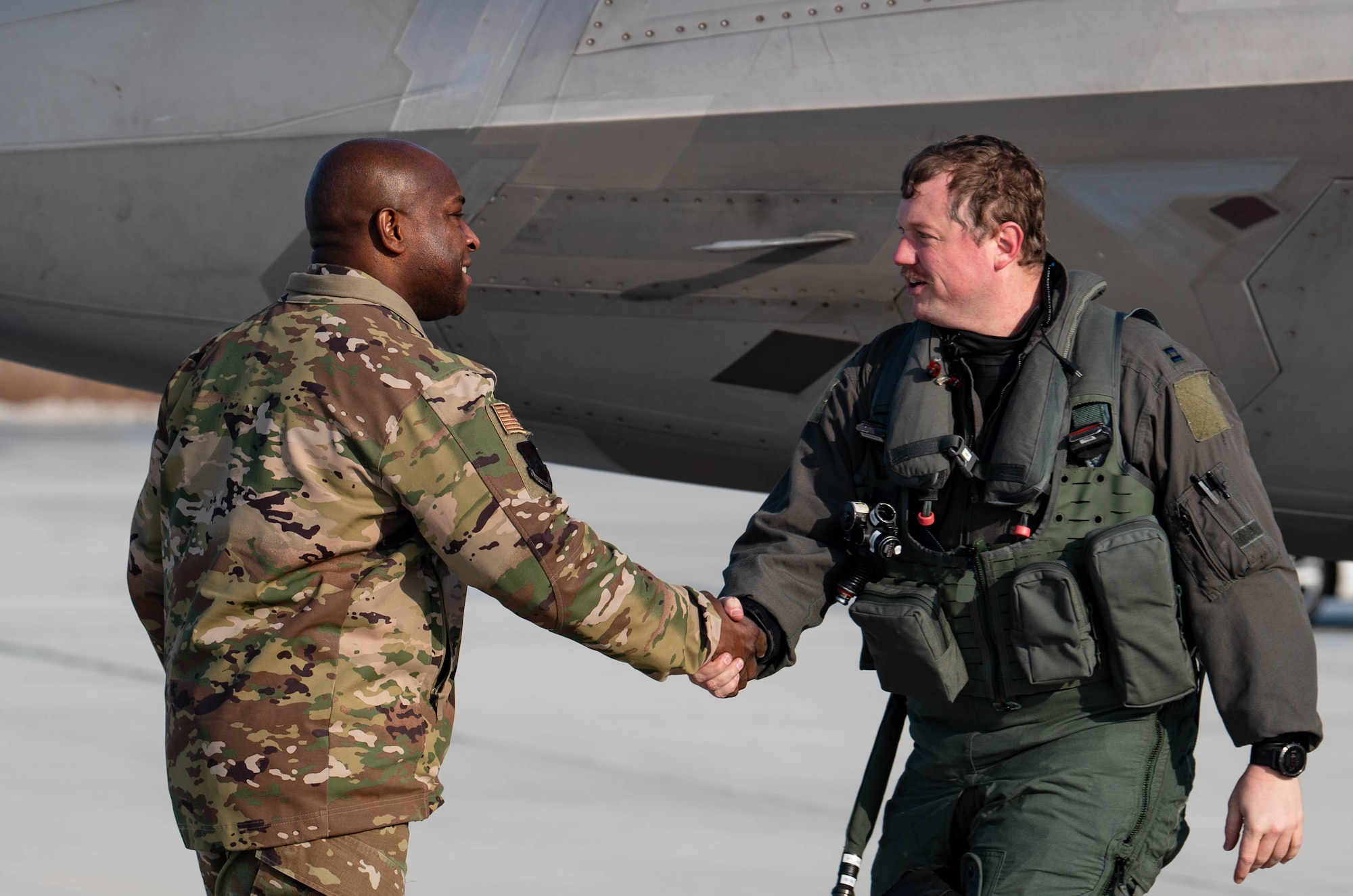 Airmen greet each other with a handshake.