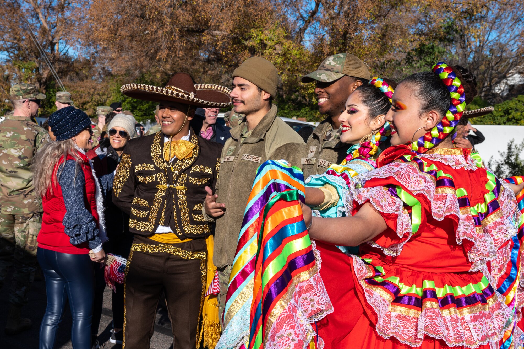 U.S. Air Force Airmen and Primavera Folklorico Dance Company performers pose for a photo during the Fiesta Bowl Parade, Dec. 17, 2022, in Phoenix, Arizona.