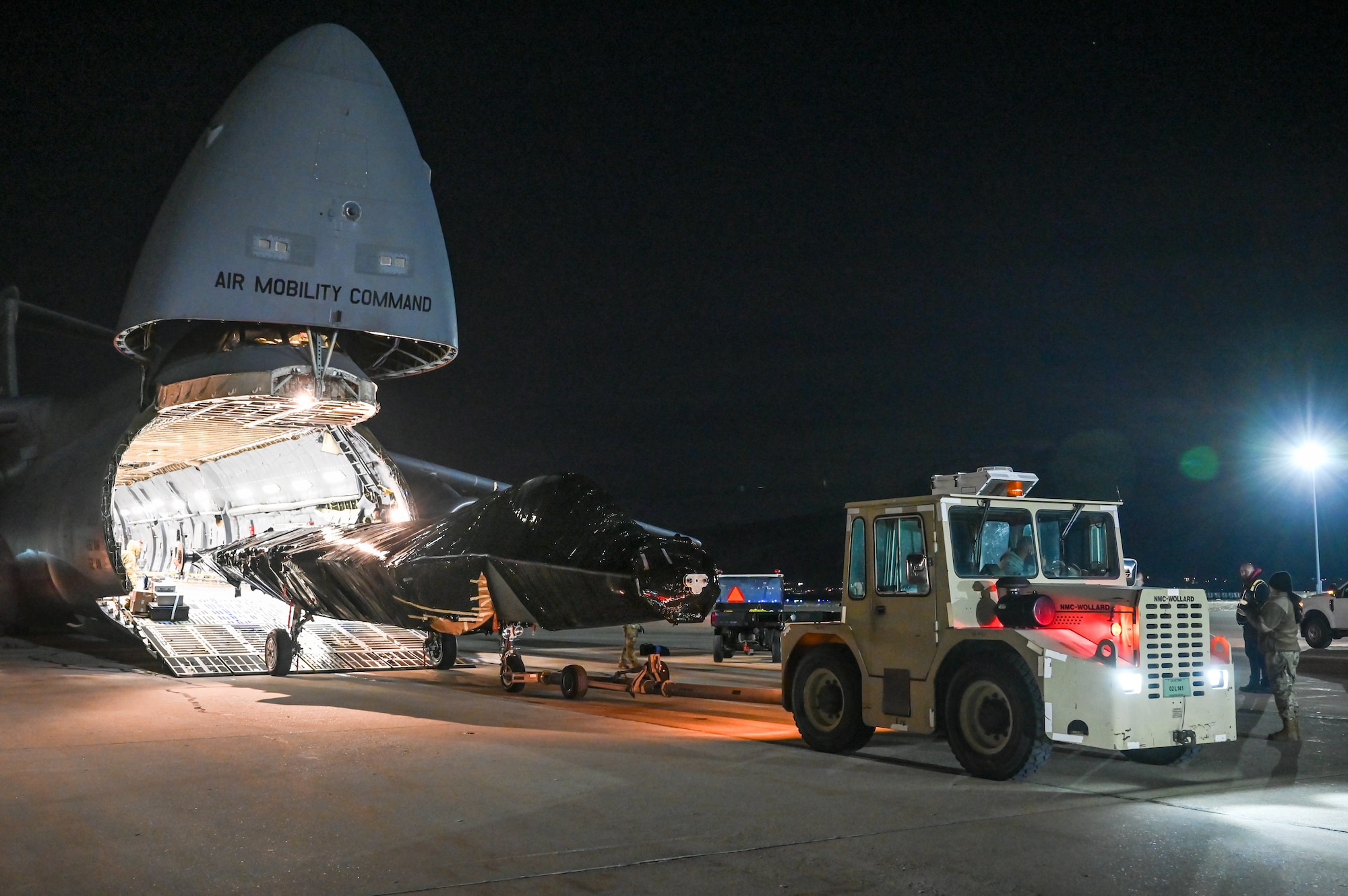 The fuselage of an F-22 Raptor emerges from inside a C-5M Galaxy