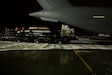 A truck filled with cargo backs up to a plane.