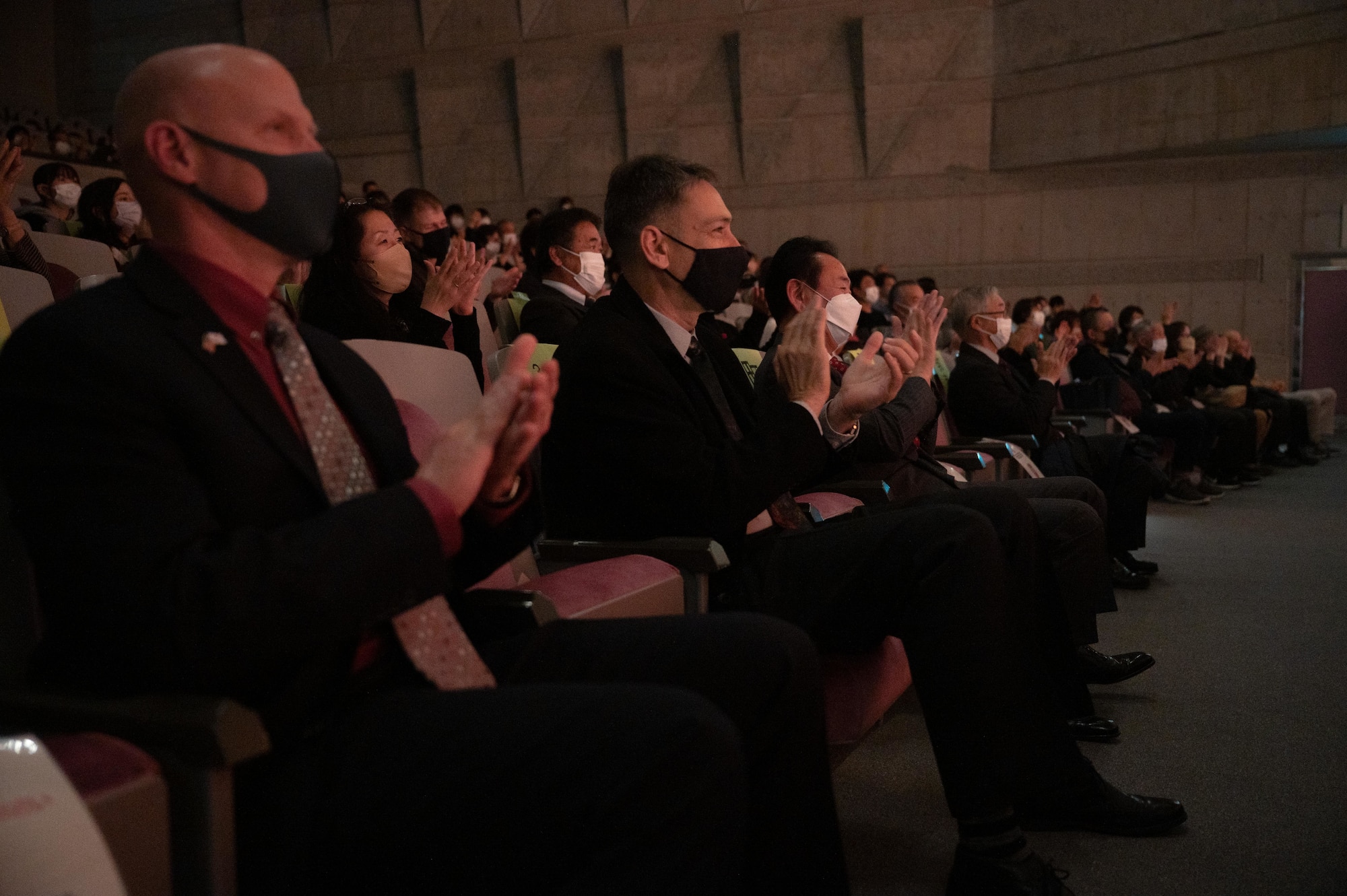 Audience members clap for a concert performance