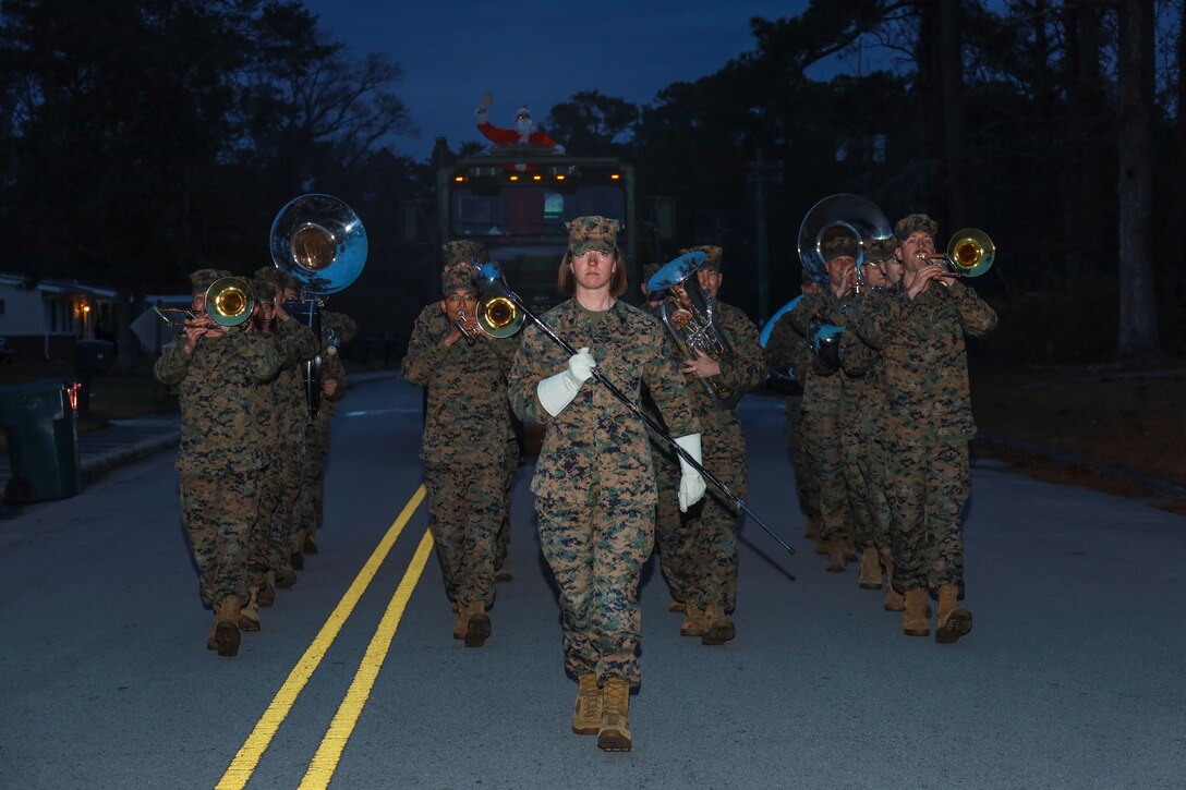 U.S. Marines with 2nd Marine Aircraft Wing (2D MAW) Band march down the streets of Nugent Cove Housing during their 3rd annual Christmas Parade at Marine Corps Air Station Cherry Point, North Carolina, Dec. 14, 2022. During the month of December, the 2D MAW Band parades through housing on the installation playing Christmas songs to spread festive cheer. (U.S. Marine Corps photo by Lance Cpl. Jade Farrington)