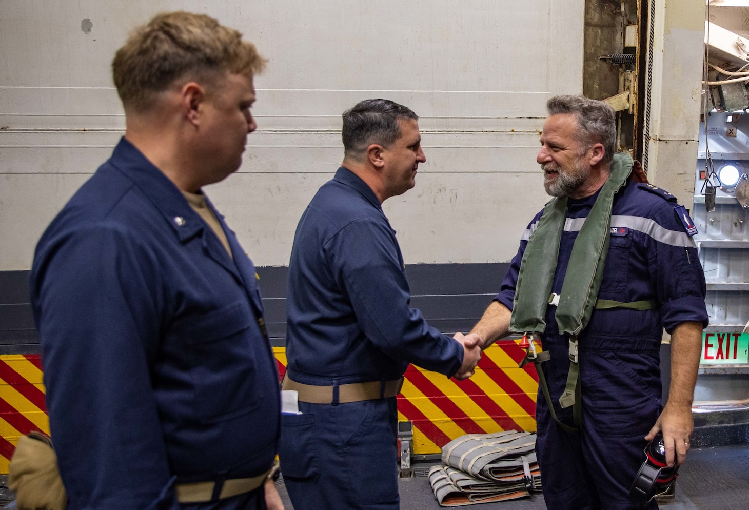 French Rear Adm. Christophe Cluzel, right, commander, French Carrier Strike Group (CSG), greets Cmdr. John Mastriani, middle, commanding officer of the Arleigh Burke-class guided-missile destroyer USS Roosevelt (DDG 80), and Cmdr. Jeffrey Chewning, left, executive officer of Roosevelt, during his visit of the ship, Nov. 27, 2022. Roosevelt, currently attached to the Charles de Gaulle CSG, is on a scheduled deployment in the U.S. Naval Forces Europe area of operations, employed by U.S. Sixth Fleet to defend U.S., allied and partner interests.