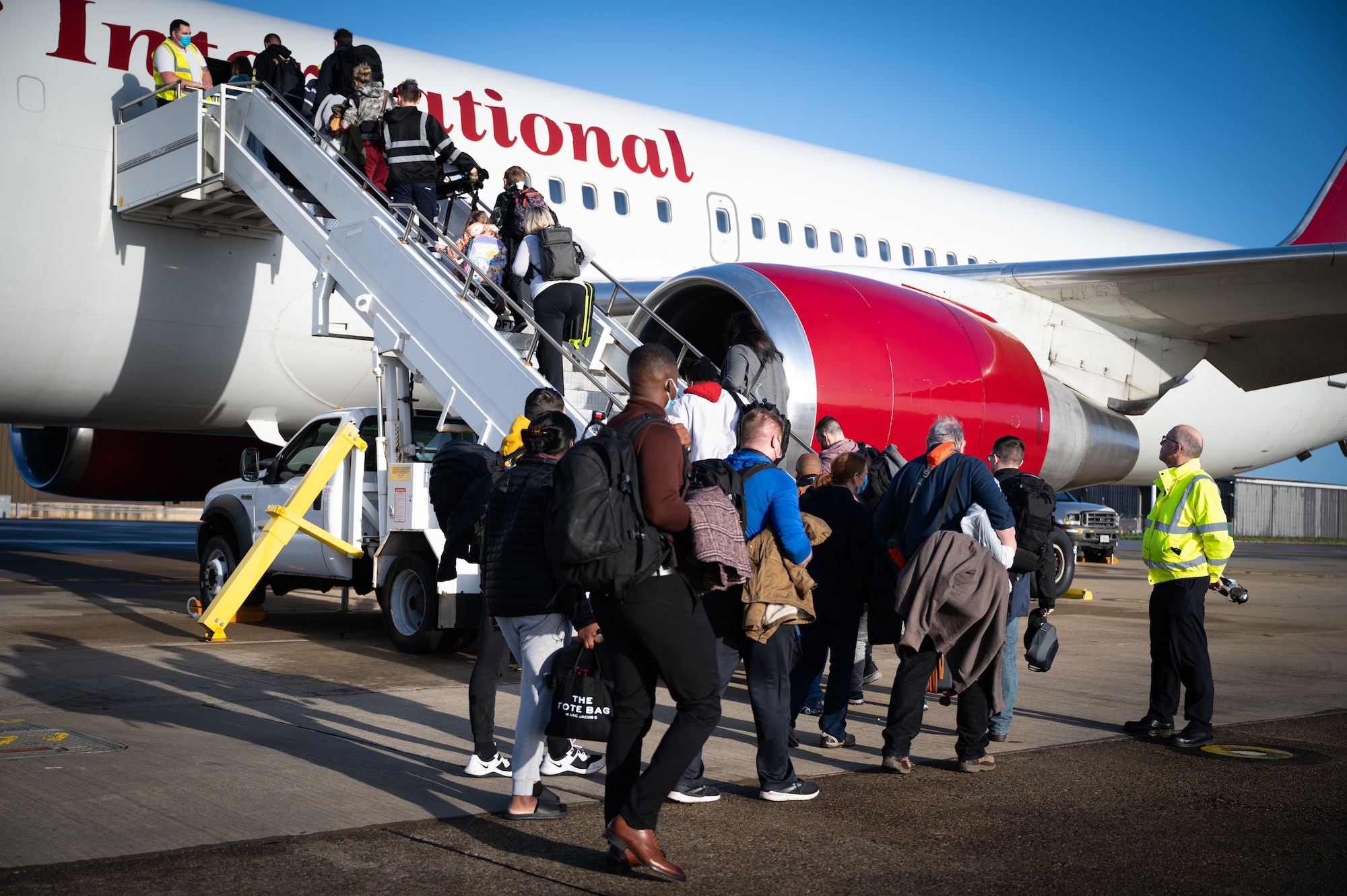 Passengers board the Patriot Express at Royal Air Force Mildenhall, England, Dec. 20, 2022. The Patriot Express flight, also known as the rotator, is a Department of Defense contracted commercial charter flight which provides international support to U.S. military and civilian members and their families permanently changing station to the United Kingdom. (U.S. Air Force photo by Airman 1st Class Viviam Chiu)