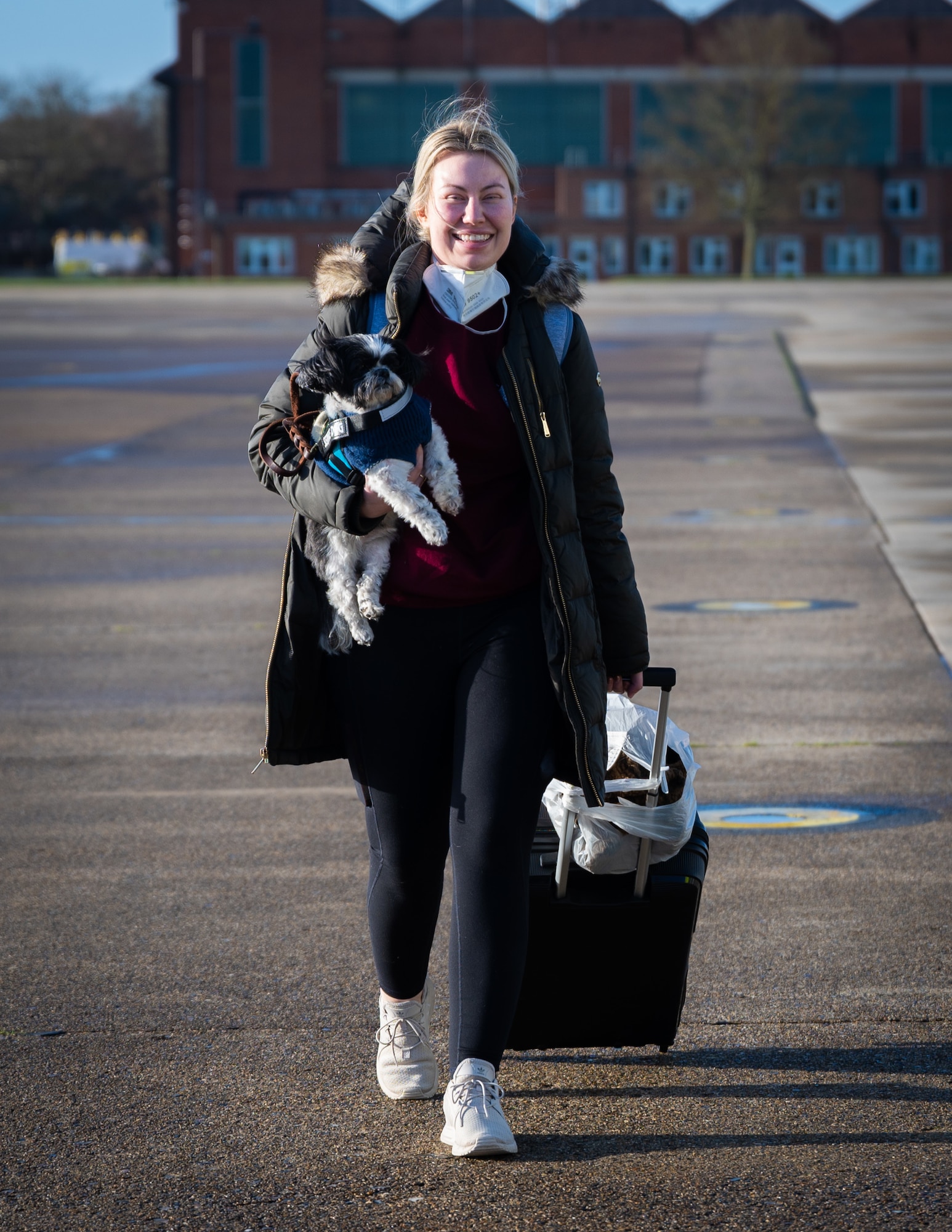 A Team Mildenhall member prepares to board the Patriot Express with her service dog at Royal Air Force Mildenhall, England, Dec. 20, 2022. The Patriot Express helps alleviate the stress of members permanently changing station to the United Kingdom by operating bi-weekly flights, and it can provide up to two pet reservations per family. (U.S. Air Force photo by Airman 1st Class Viviam Chiu)