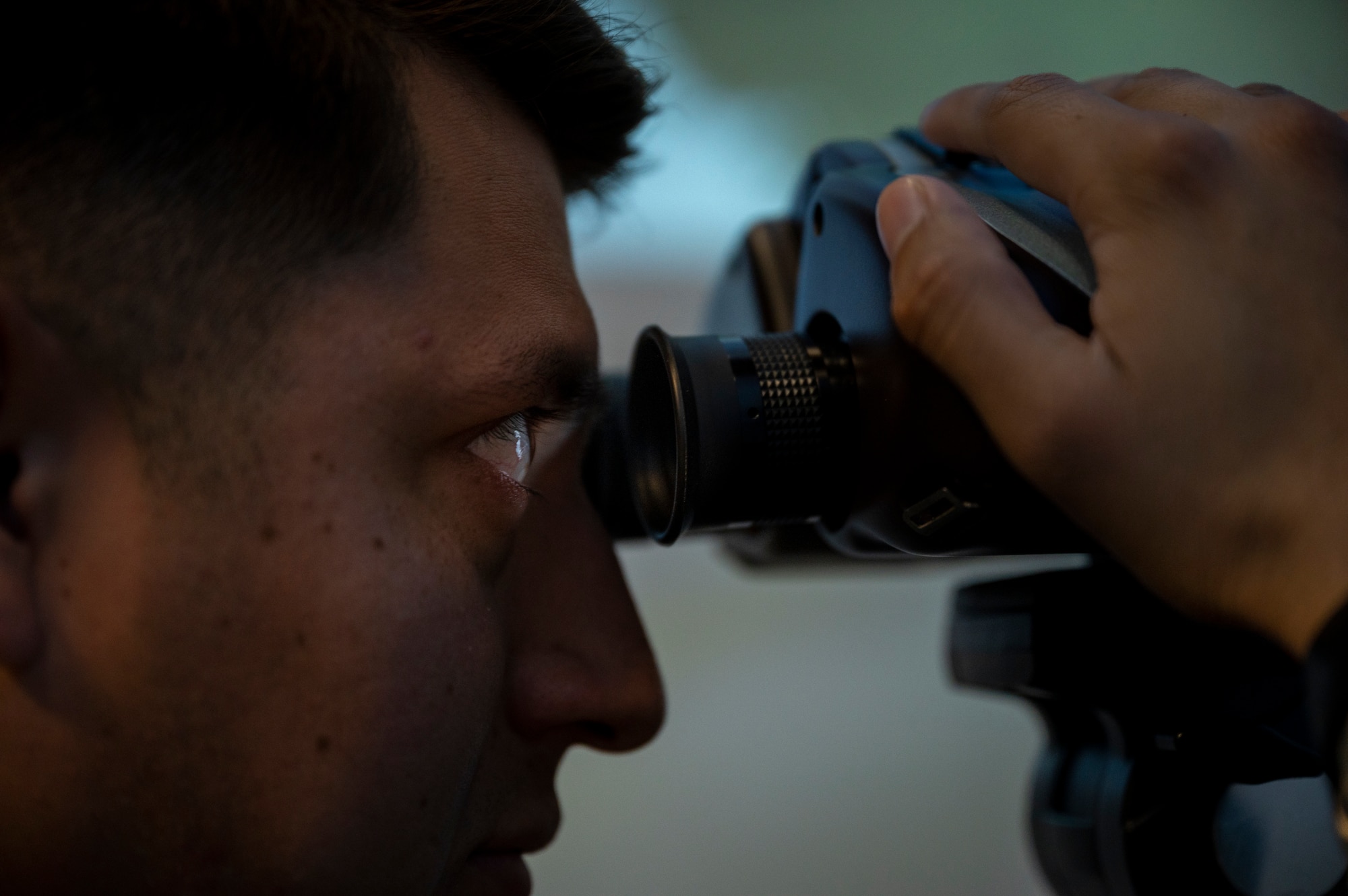 U.S. Marine Sgt. Derek Barrea-Antonio joint terminal attack controller (JTAC), 3rd Battalion, 4th Marine Regiment from Twentynine Palms Marine Corps Base, California, looks through a JTAC simulator systems binocular during a joint training at Osan Air Base, Republic of Korea, Dec. 15, 2022.
