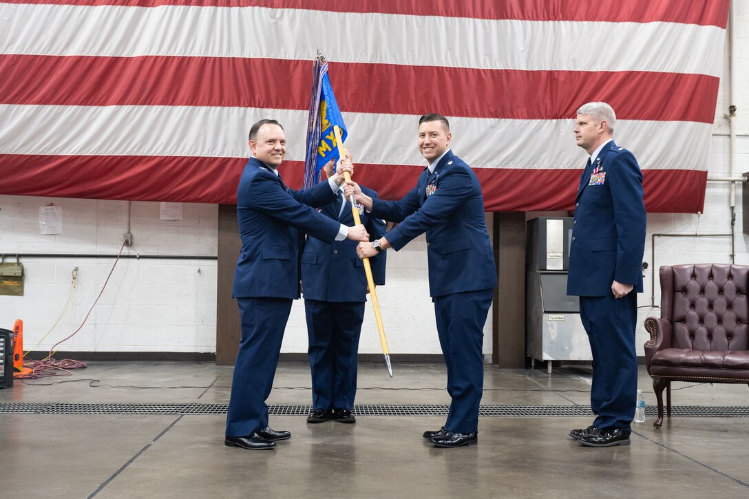 Lt. Col. Daniel Mount, the incoming 28th Maintenance Squadron commander, receives the 28th MXS guidon during a change of command ceremony at Ellsworth Air Force Base, South Dakota., Dec. 19, 2022. Presenting the unit's guidon is a symbolic gesture of handing the command of a squadron, or wing, to a gaining officer. (U.S. Air Force photo by Staff Sgt. Hannah Malone)