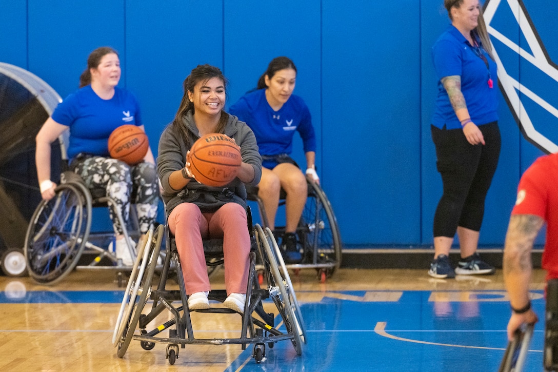 Athletes and volunteers practice wheelchair basketball.