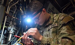 U.S. Army Pvt. Travis McCool, 128th Aviation Brigade, 210th Aviation Regiment, 1st Battalion, Advanced Individual Training student, inspects the tip of an electrical wire on a CH-47 Chinook helicopter simulator at Joint Base Langley-Eustis, Virginia, Dec. 15, 2022. Approximately 250 new Soldiers pass though the 128th Aviation Brigade’s aircraft electrician ‘15F’ military occupational specialty course each year. (U.S. Air Force photo by Abraham Essenmacher)