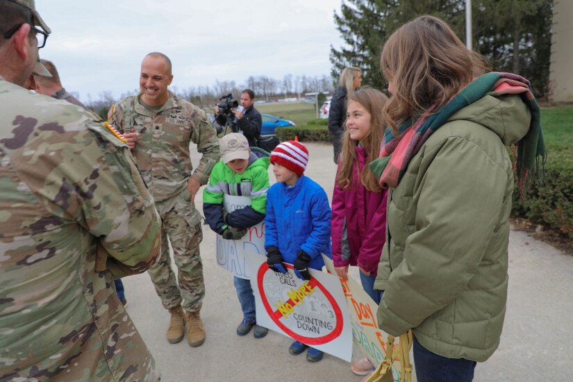 Lt. Col. Jason Mendez, commander of the 1st Battalion, 149th Infantry Brigade, shares a laugh with his family at the Bluegrass Airport in Lexington, Ky., after he and his unit arrived home from their deployment to Kosovo Nov. 17, 2022.