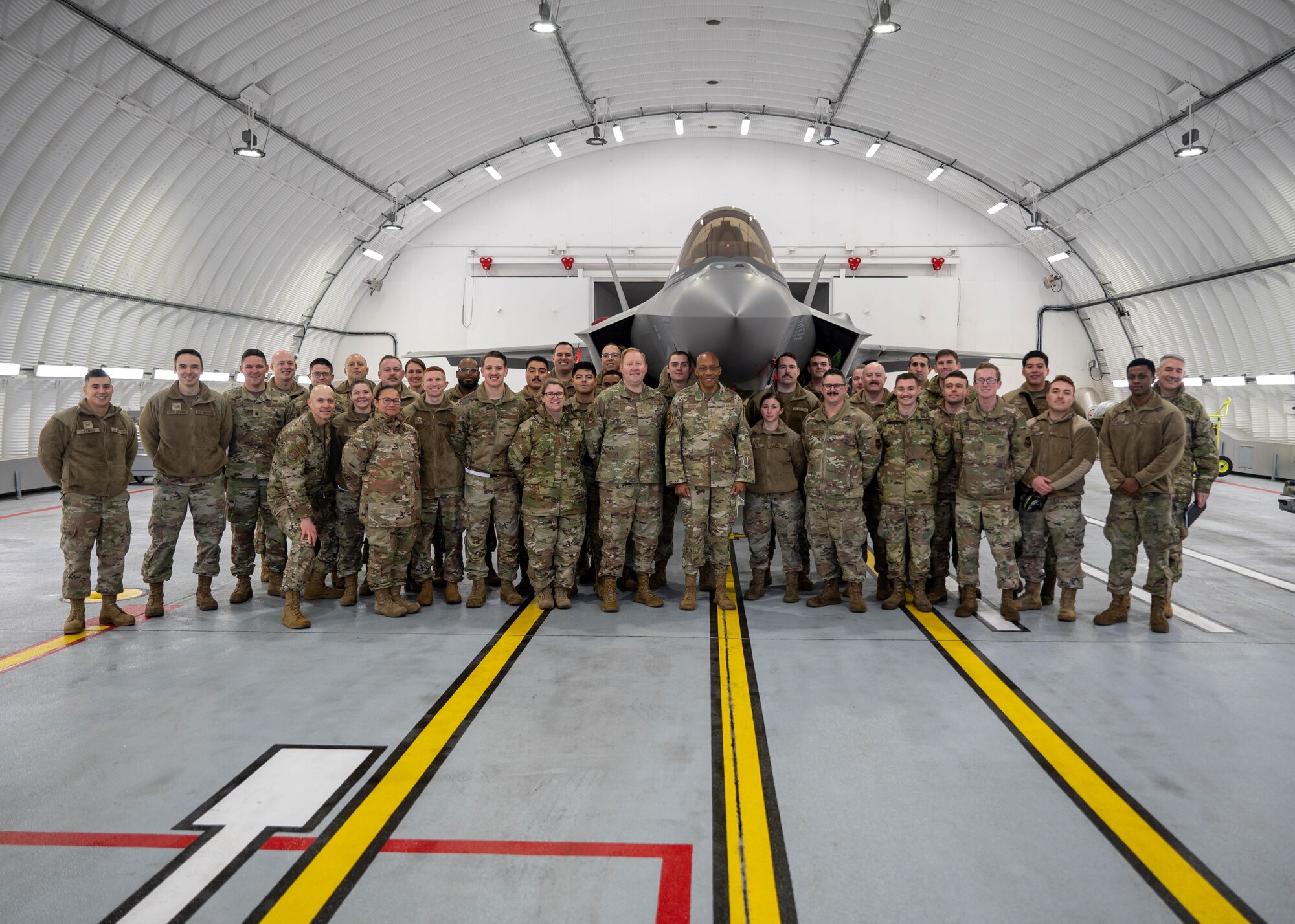 A group of Airmen stand in front of a fighter plane.