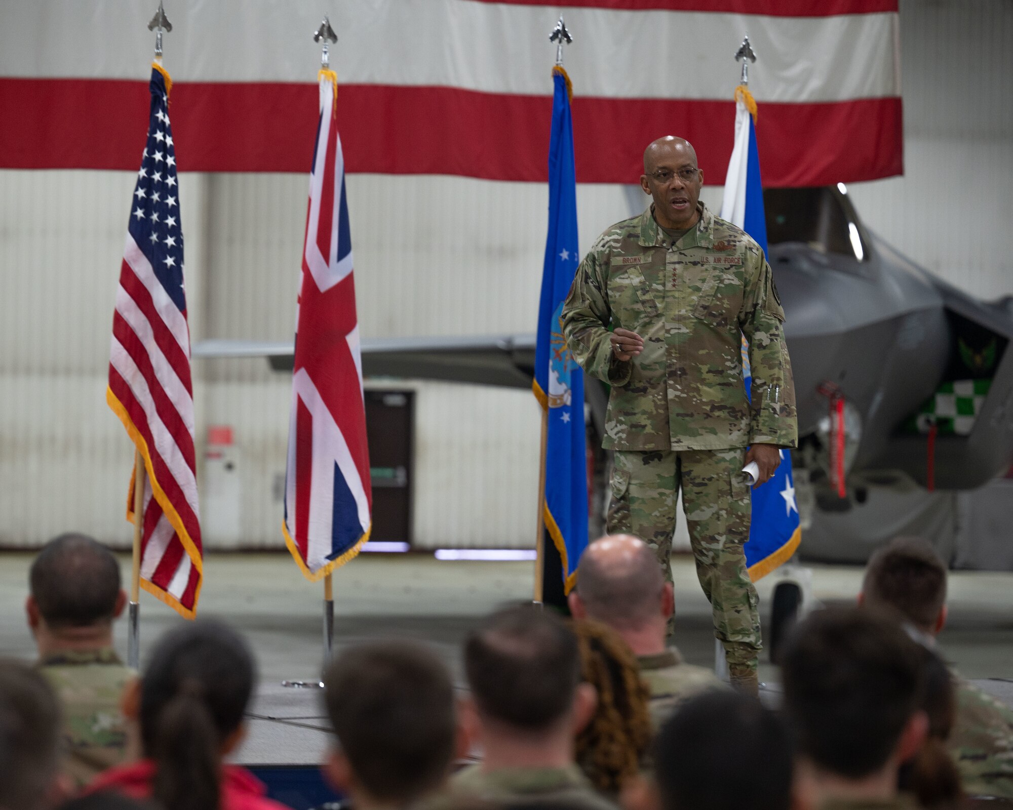 The Air Force Chief of Staff speaks to a crowd in front of a plane.