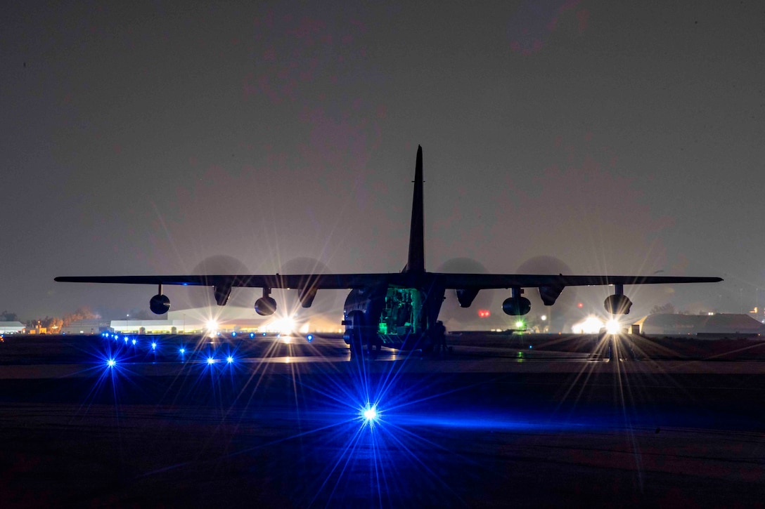 An aircraft on a flightline at night.