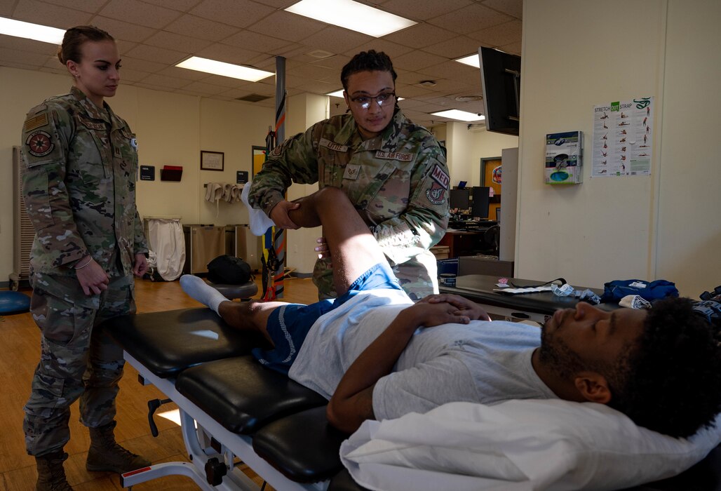 Image of Airmen providing medical attention to another person.