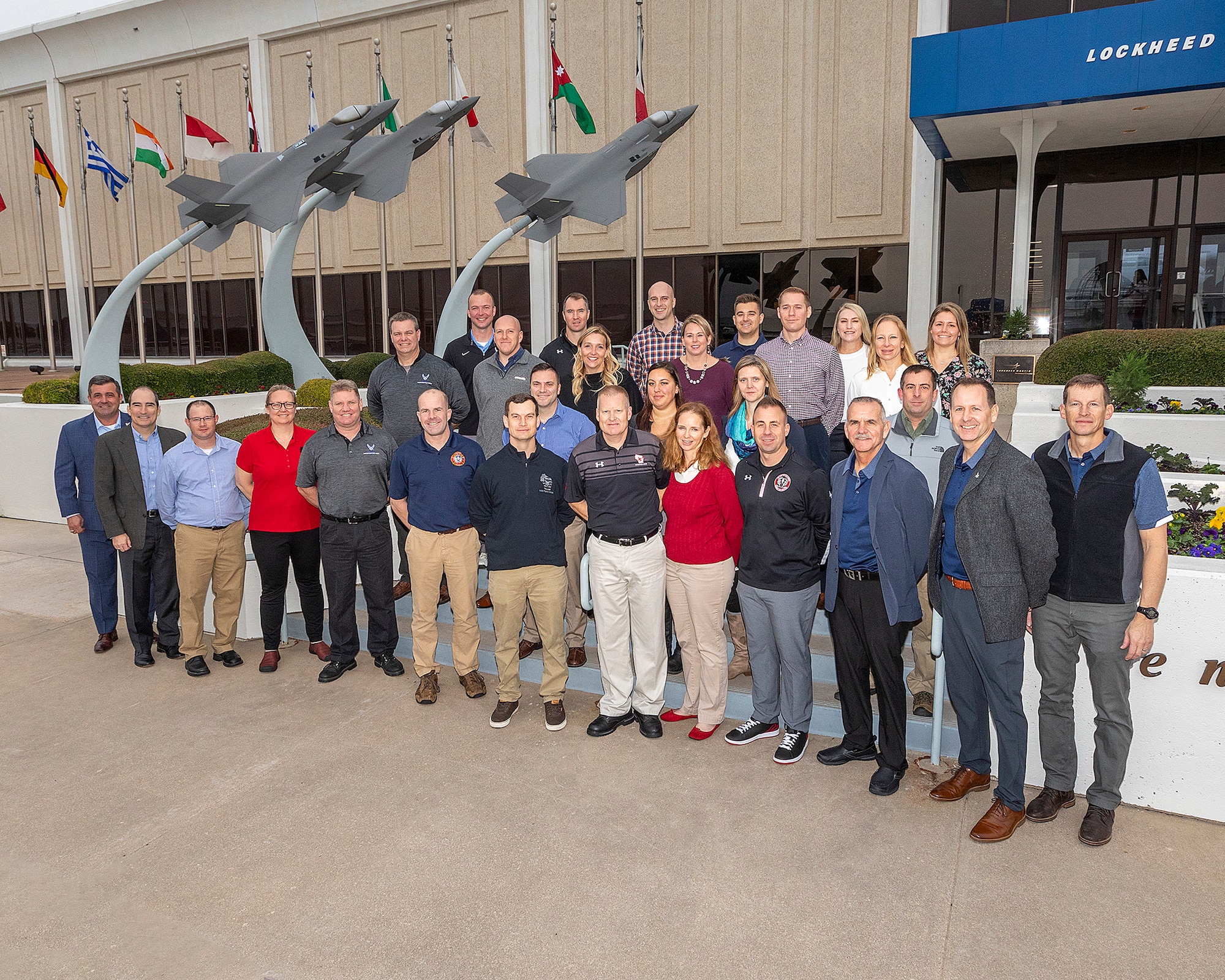 115th Fighter Wing members pose for a group photo at the entrance of Lockheed Martin Aeronautics