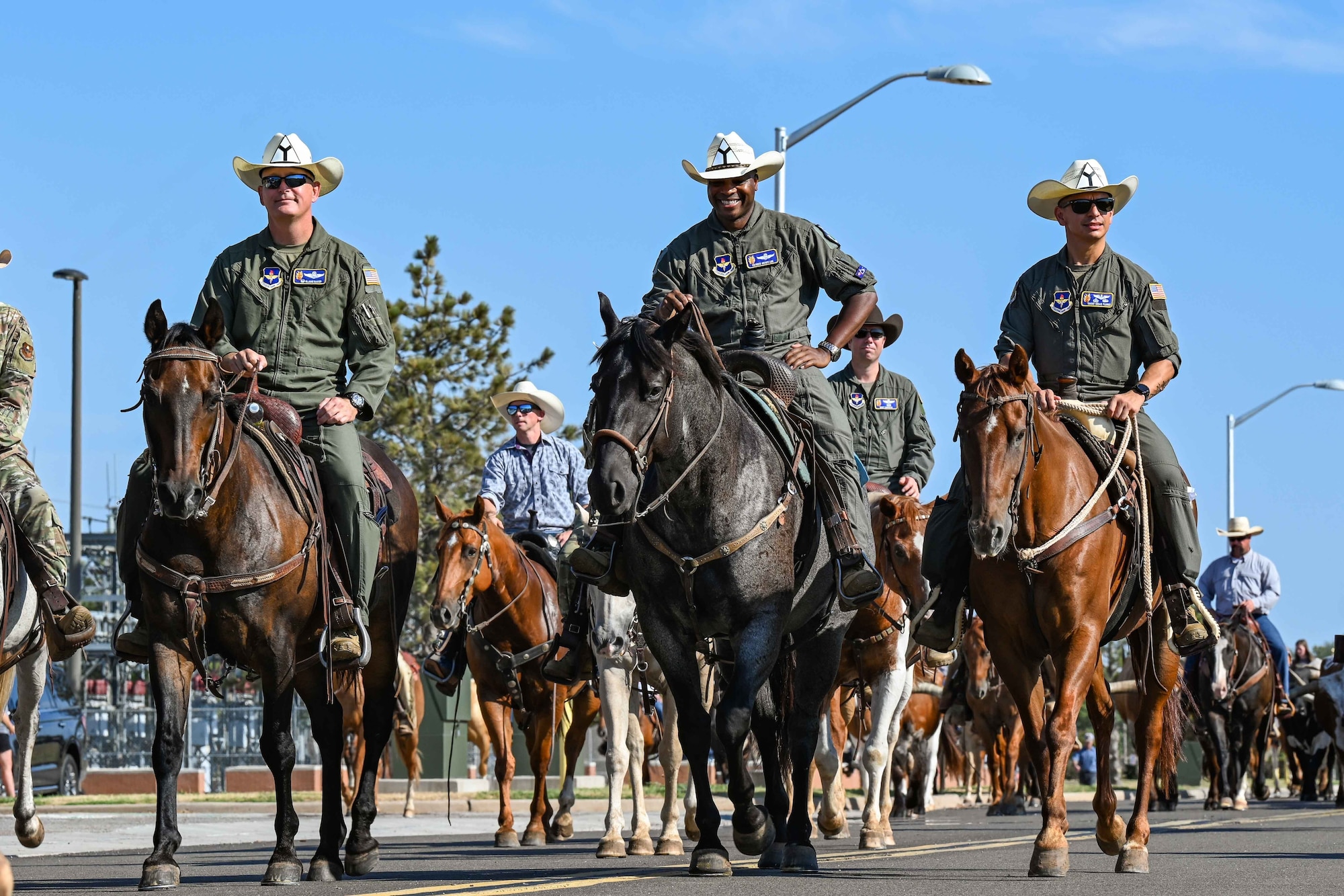 From left, U.S. Air Force Col. Blaine Baker, 97th Air Mobility Wing (AMW) commander, Col. Patrick Brady-Lee, 97th AMW vice commander and Chief Master Sgt. Cesar Flores, 97th AMW command chief, ride through Altus Air Force Base, Oklahoma during the 23rd Annual Cattle Drive on Aug. 25, 2022. Leadership participates in the cattle drive every year to show support for the community of Altus and continue over 23 years of tradition. (U.S. Air Force photo by Staff Sgt. Breanna Klemm)