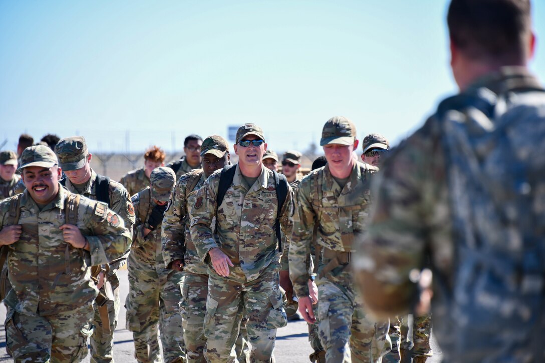 Members from the 97th Security Forces Squadron are joined by U.S. Air Force Col. Blaine Baker, 97th Air Mobility Wing commander, during their 3.5 mile ruck across Altus Air Force Base, Oklahoma, Oct. 21, 2022. Day three of The Standard resiliency course began with several physical fitness exercises, a defenders challenge test, and concluded with the ruck back to the Security Forces Squadron. (U.S. Air Force photo by Kari Degraffenreed)