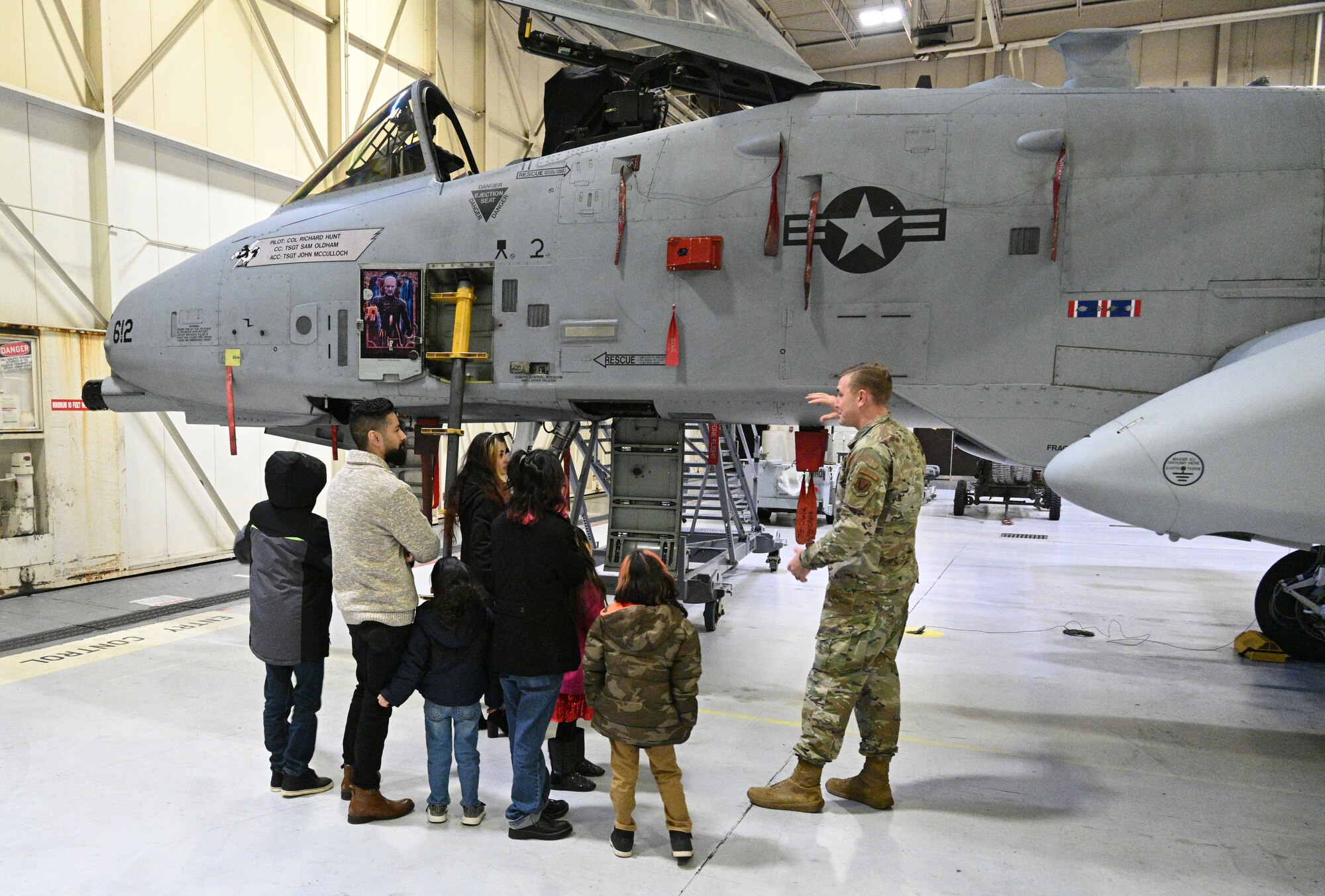 U.S. Air Force Tech. Sgt. Eric Hollman, 175th Wing recruiter, gives a tour of the A-10C Thunderbolt II aircraft to the Chavez family at Warfield Air National Guard Base at Martin State Airport, Middle River, Md., on December 20, 2022.