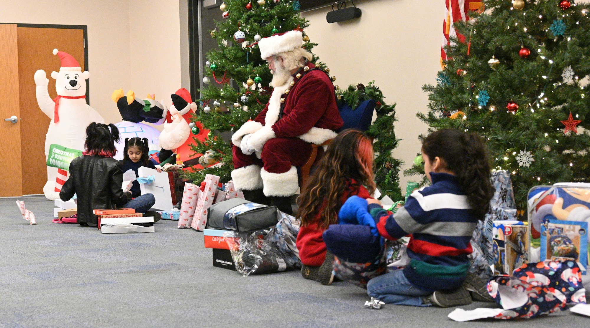 The Chavez family opens gifts at Warfield Air National Guard Base at Martin State Airport, Middle River, Md., on December 20, 2022.