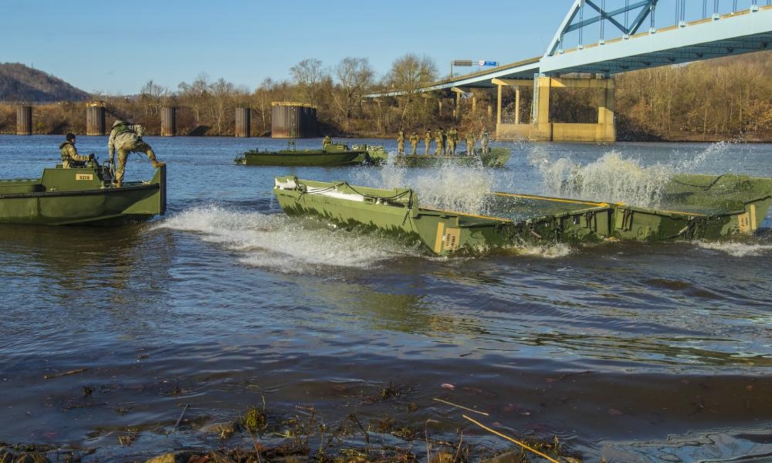 Soldiers for the 459th Engineer Company unload an Improved Ribbon Bridge into the Ohio River during a wet gap crossing training exercise with the 363rd Military Police Company.