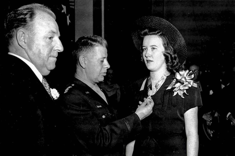 A man puts a medal around a woman’s neck.