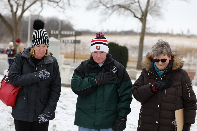 Elk Grove Village Trustee Chris Prochno, left, Elk Grove Village Mayor Craig Johnson, center, and Jane Gregga, Eli Skinner Chapter, Daughters of the American Revolution and Chapter Coordinator for Wreaths Across America, pay tribute at the grave of Revolutionary War veteran Eli Skinner at the Elk Grove Cemetery, 25 miles northwest of Chicago, December 17, 2022.