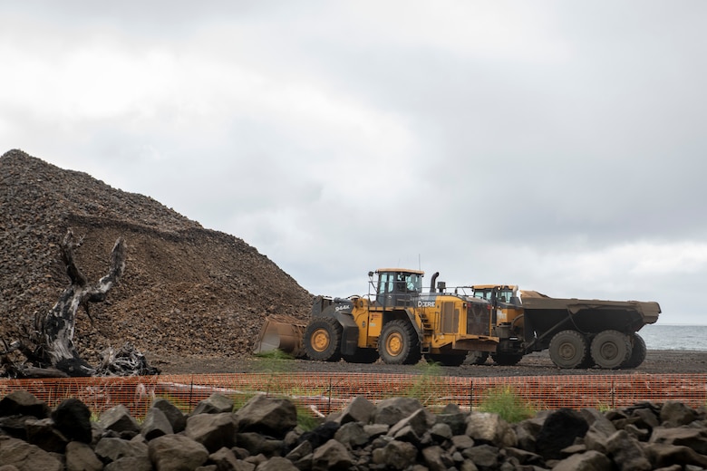 Photo of construction truck and dump truck waiting to load road and transport materials.