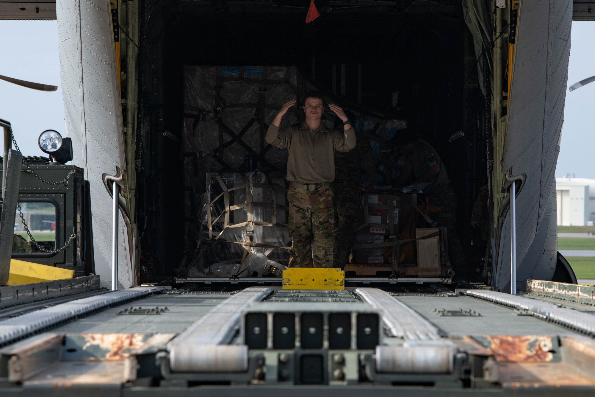 An Airman marshals a cargo vehicle.