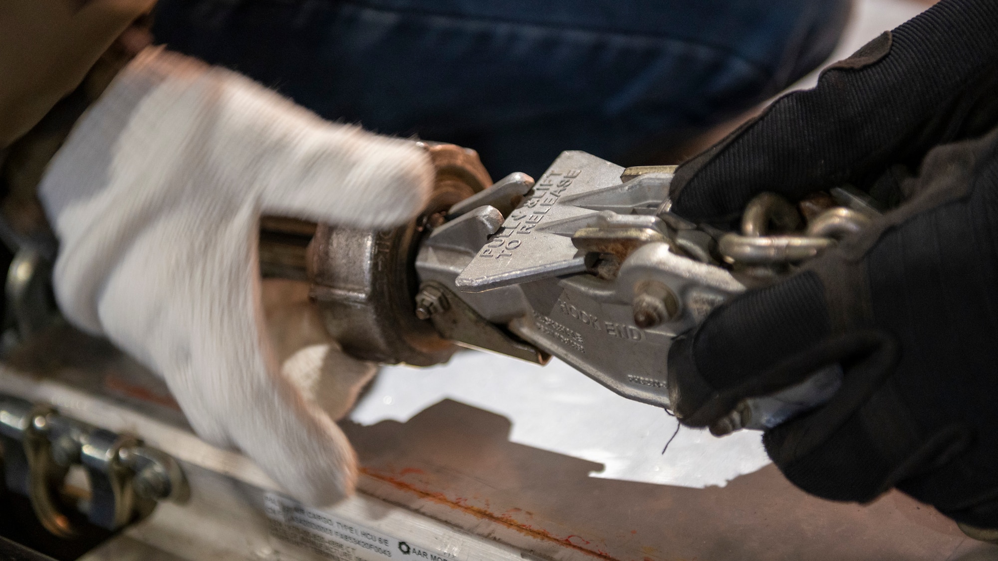 A close up of hands tightening a chain strap