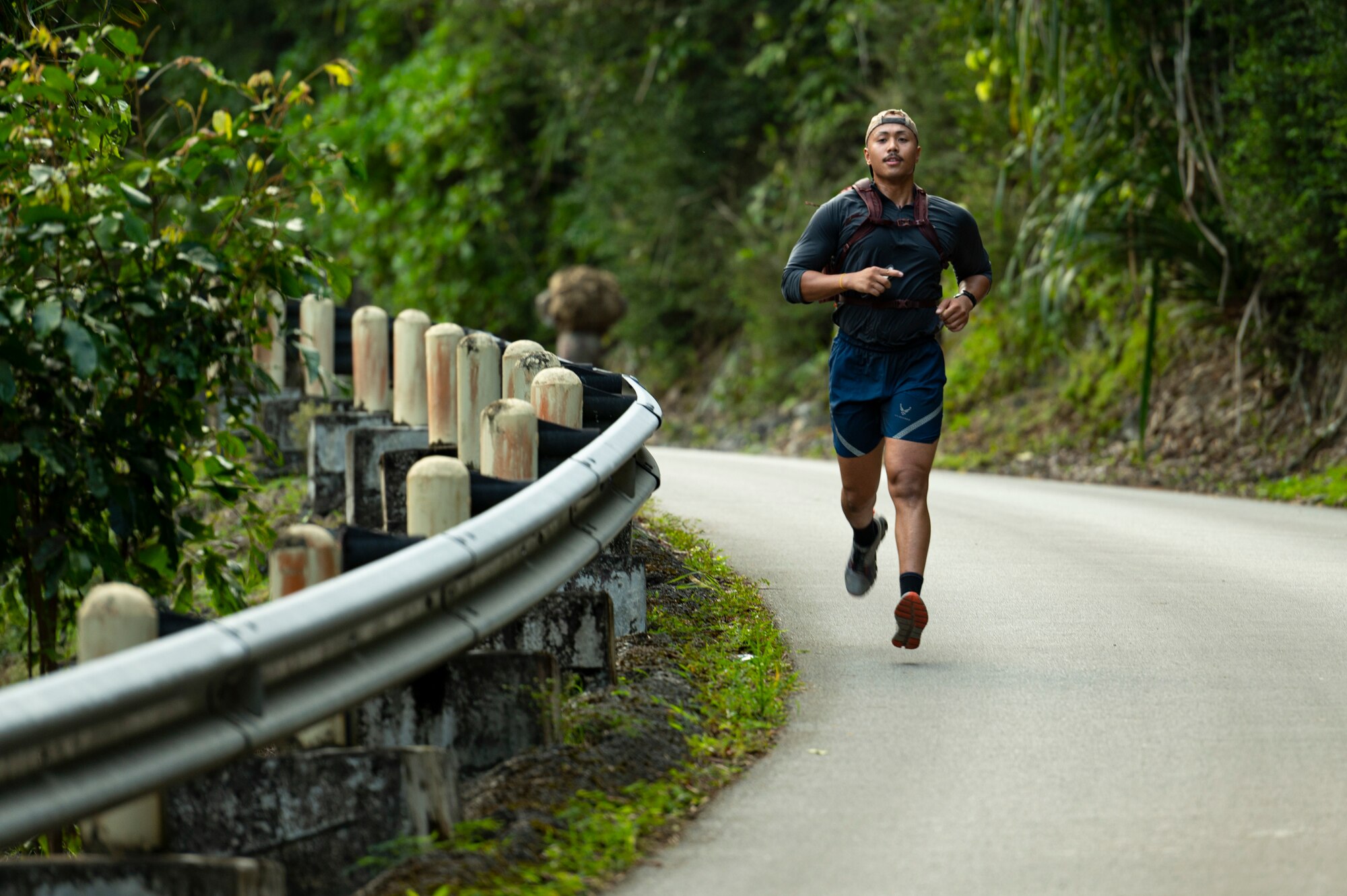 A U.S. Air Force service member runs down Slanders Slope during the Office of Special Investigations’ Hustler-6 memorial event on Andersen Air Force Base, Guam, Dec. 21, 2022. Since 2016, OSI agents assigned to Andersen AFB have annually honored the Hustler-6, who lost their lives during a mission near Bagram, Afghanistan on Dec. 21, 2015, by rucking up and down Sanders Slope. (U.S. Air Force photo by Airman Spencer Perkins)