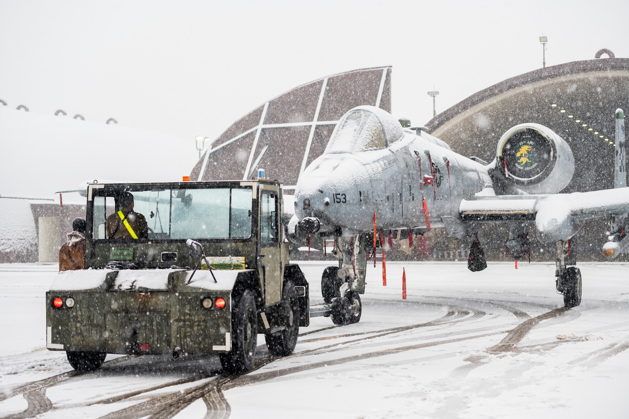 25th Fighter Generation Squadron crew chiefs relocate an A-10C Thunderbolt II from the flightline into a hangar using an aircraft tow vehicle during an FGS training event