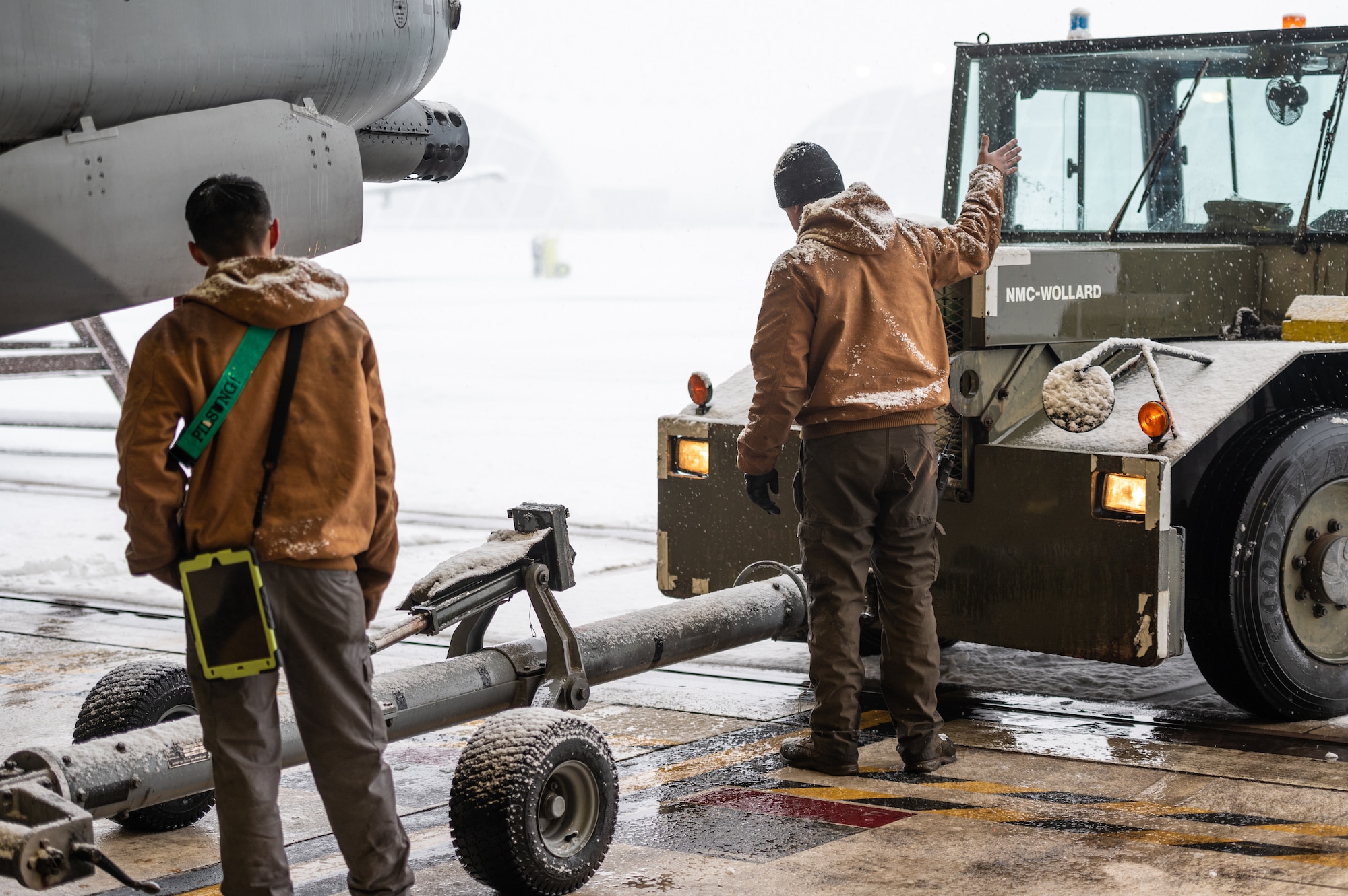 U.S. Air Force Staff Sgts. John-Michael Salenga and Manuel Baryon, 25th Fighter Generation Squadron crew chiefs, guide an aircraft tow vehicle while relocating an A-10C Thunderbolt II from the flightline to a hangar as part of an FGS training event