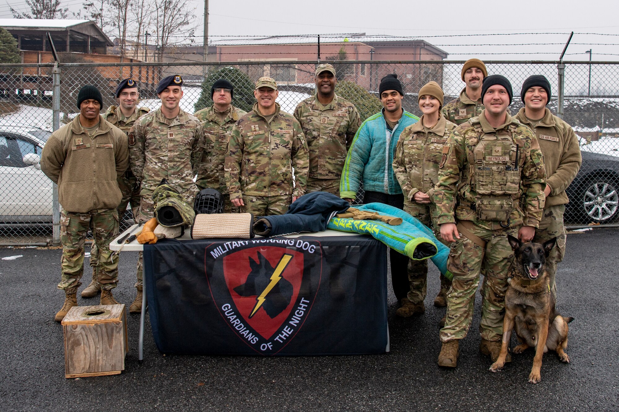 U.S. Air Force Lt. Gen. Scott Pleus (middle-left), 7th Air Force commander and U.S. Air Force Chief Master Sgt. Alvin Dyer (middle-right), 7th AF command chief, take a group photo with 51st Security Forces Squadron (SFS) members at the 51st SFS military working dog facility, Dec. 21, 2022, at Osan Air Base, Republic of Korea.