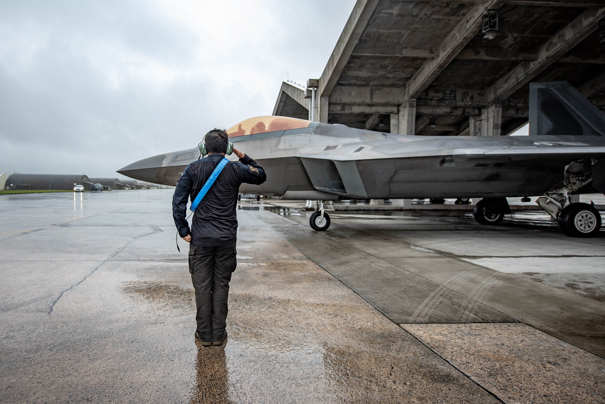 An Airman salutes an aircraft.