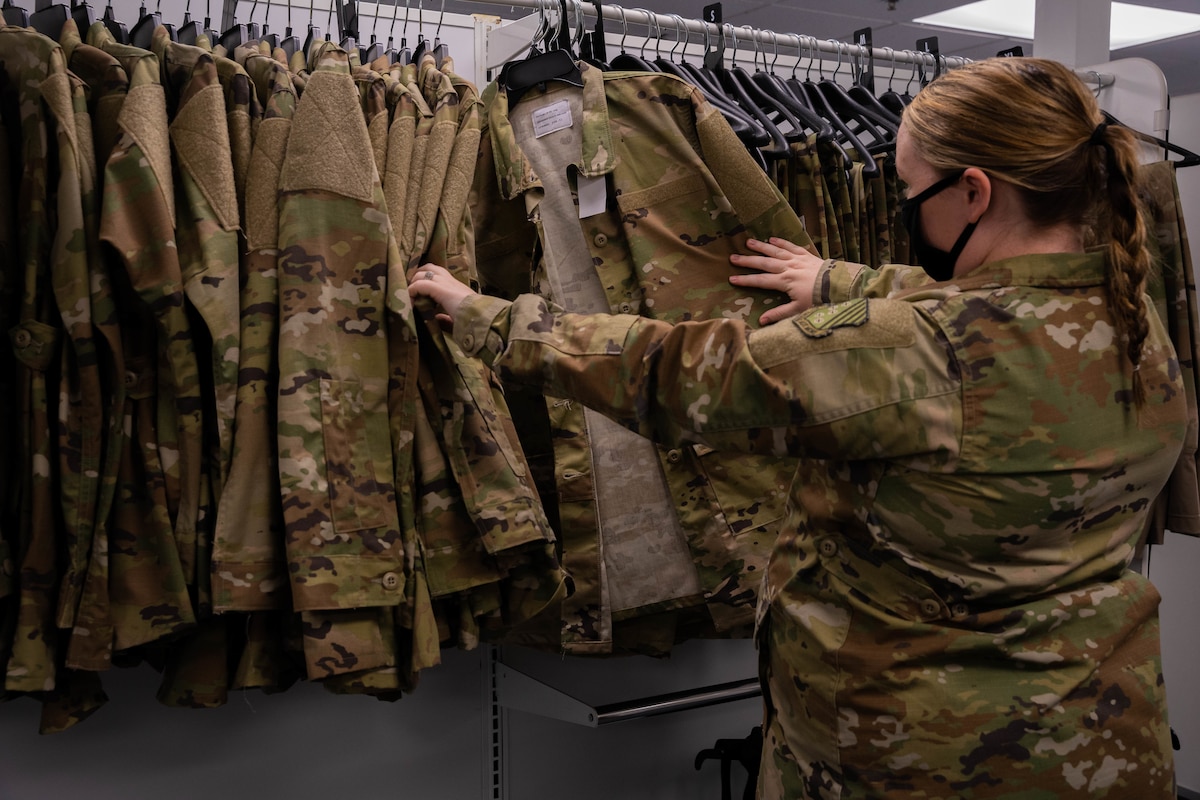 Airman looks through maternity uniform options