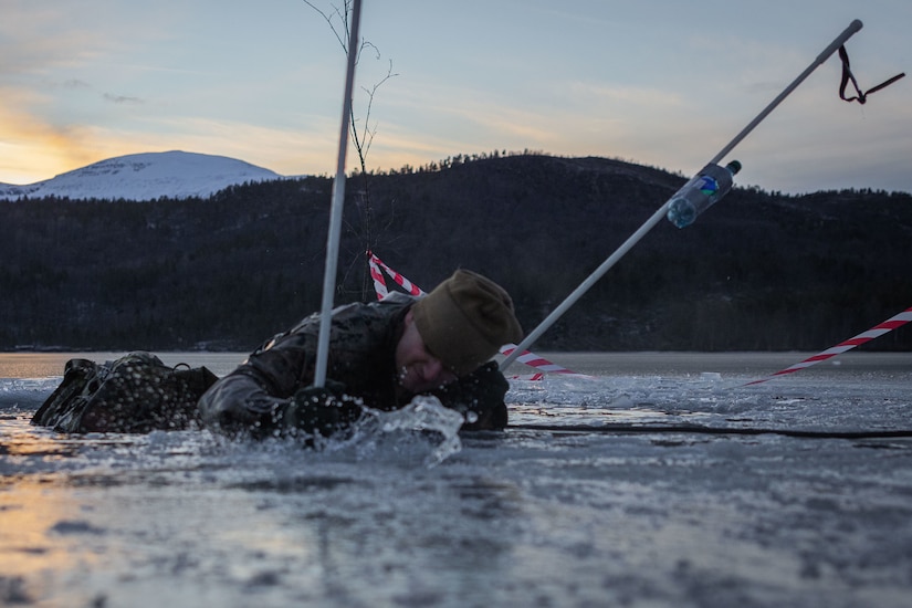 A man in military uniform gets out of icy water