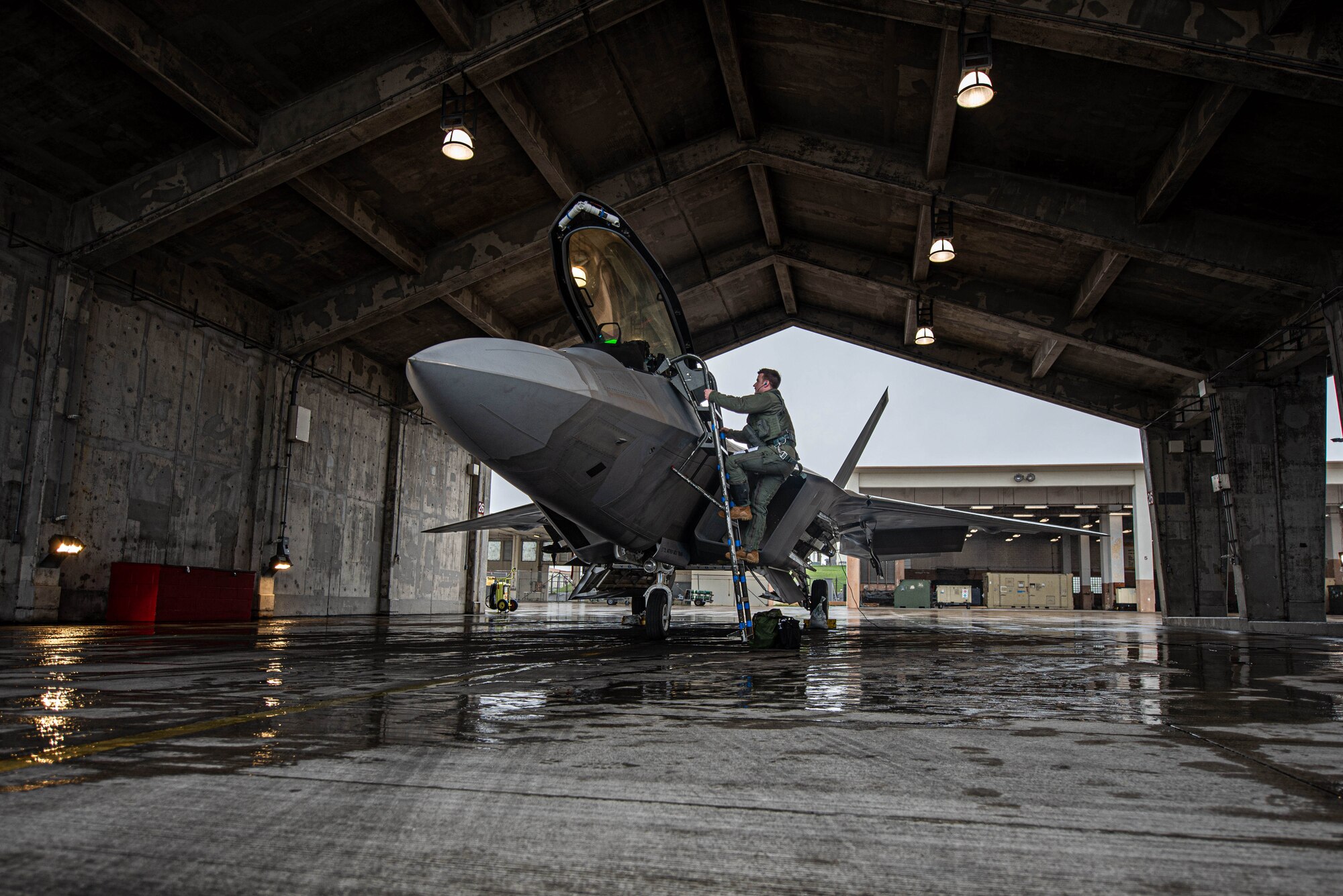 A pilot climbs into an aircraft's cockpit.