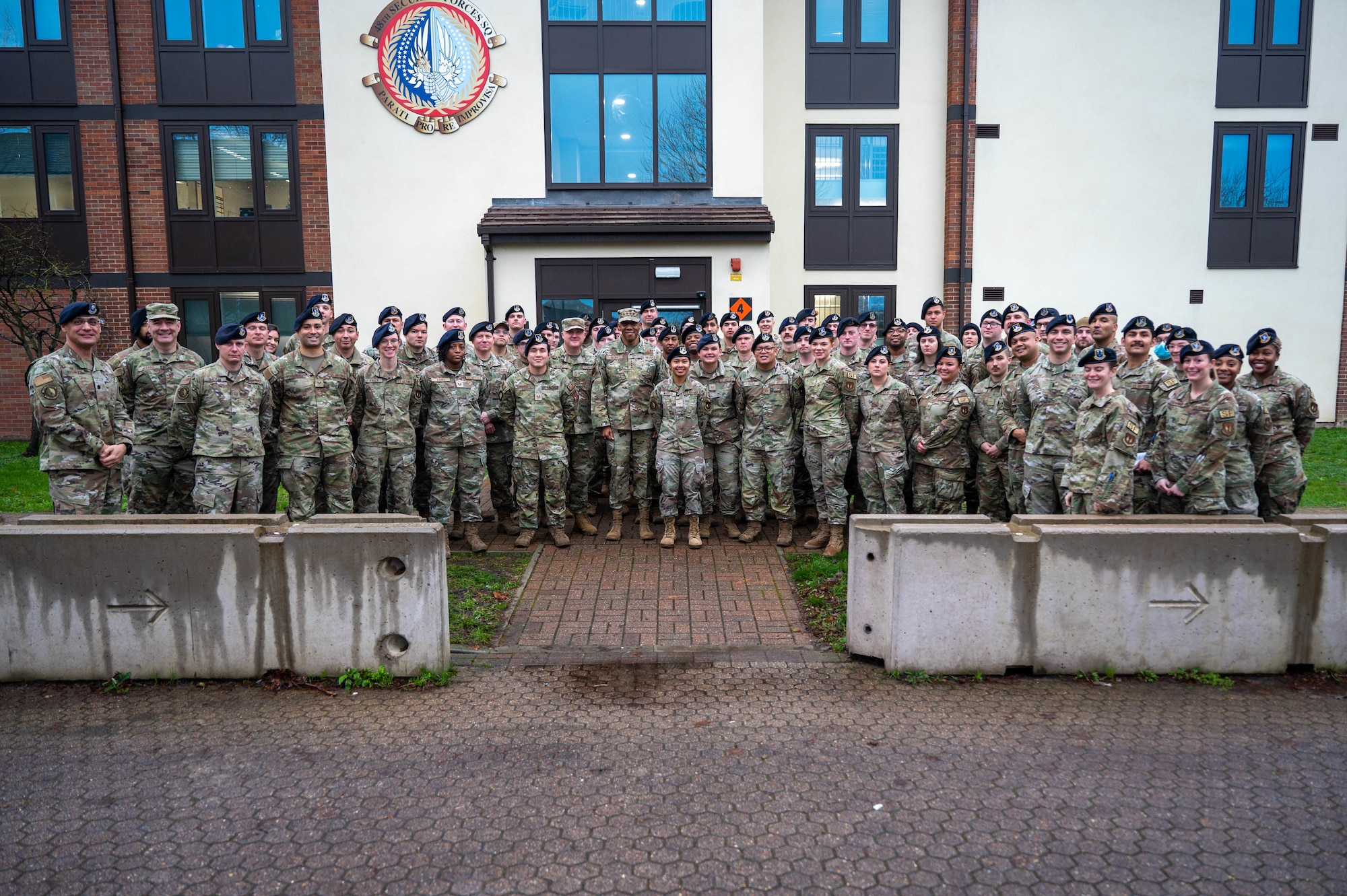 A group of Airmen stand in front of a building.