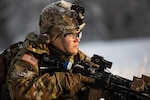 Spc. Megan Koszarek, an infantryman with the Alaska Army National Guard’s Avalanche Company, 1st Battalion, 297th Infantry Regiment, conducts a security sweep during a training exercise near Joint Base Elmendorf-Richardson, Alaska, Dec. 3, 2022. The exercise's aim was to enhance the unit’s combat readiness and evaluate proficiency in an arctic environment.
