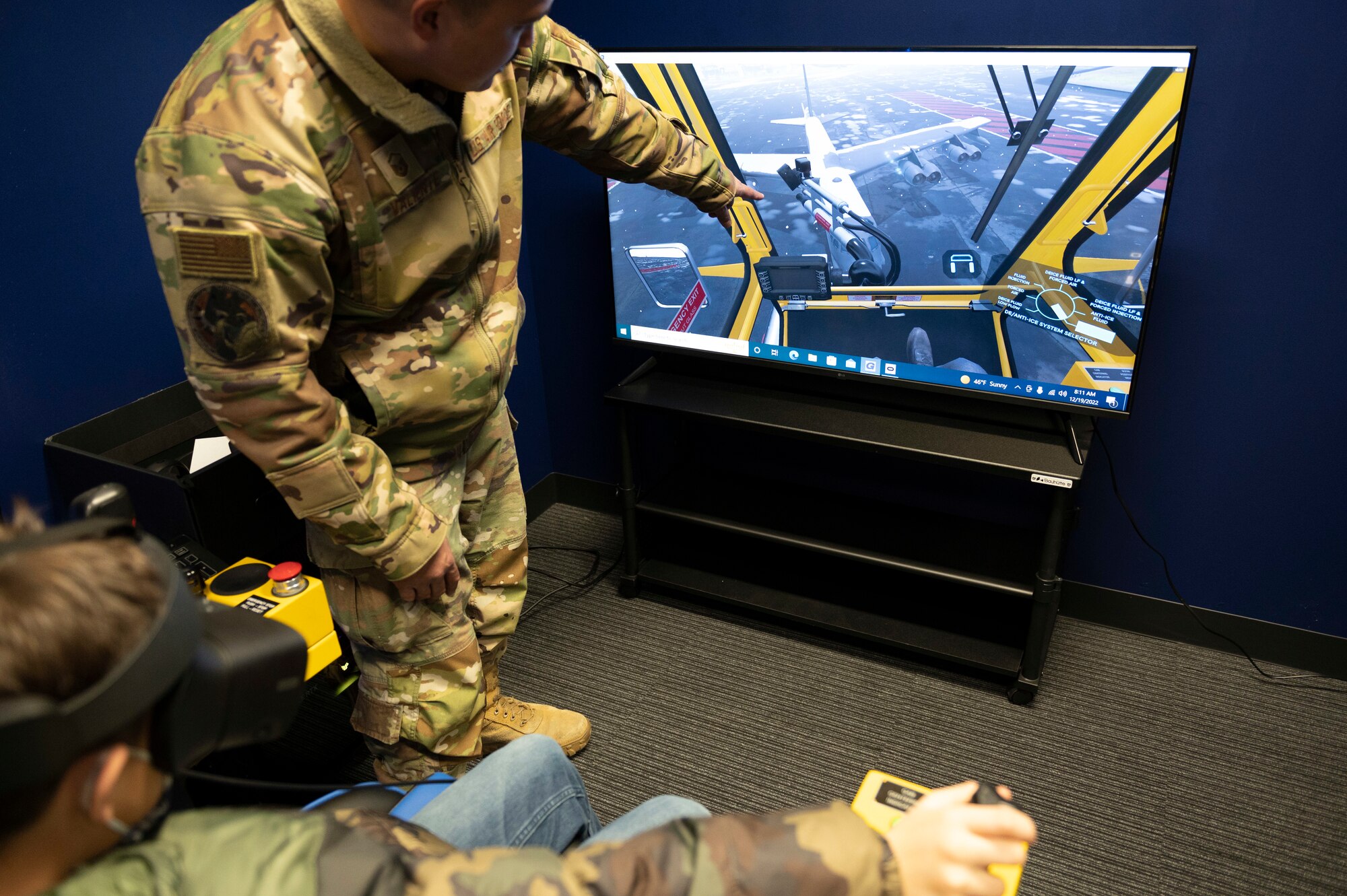 A tour guide points at a TV screen