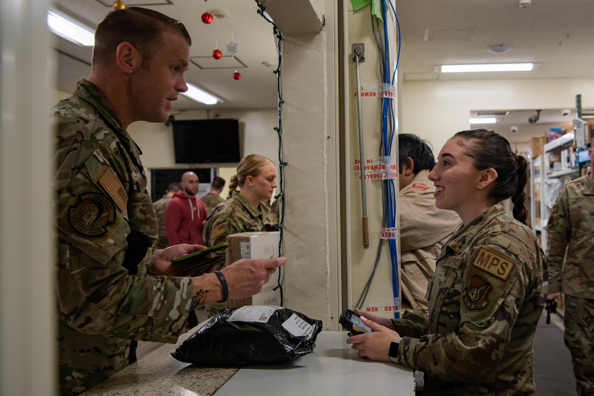 An Airman gives mail to a customer.