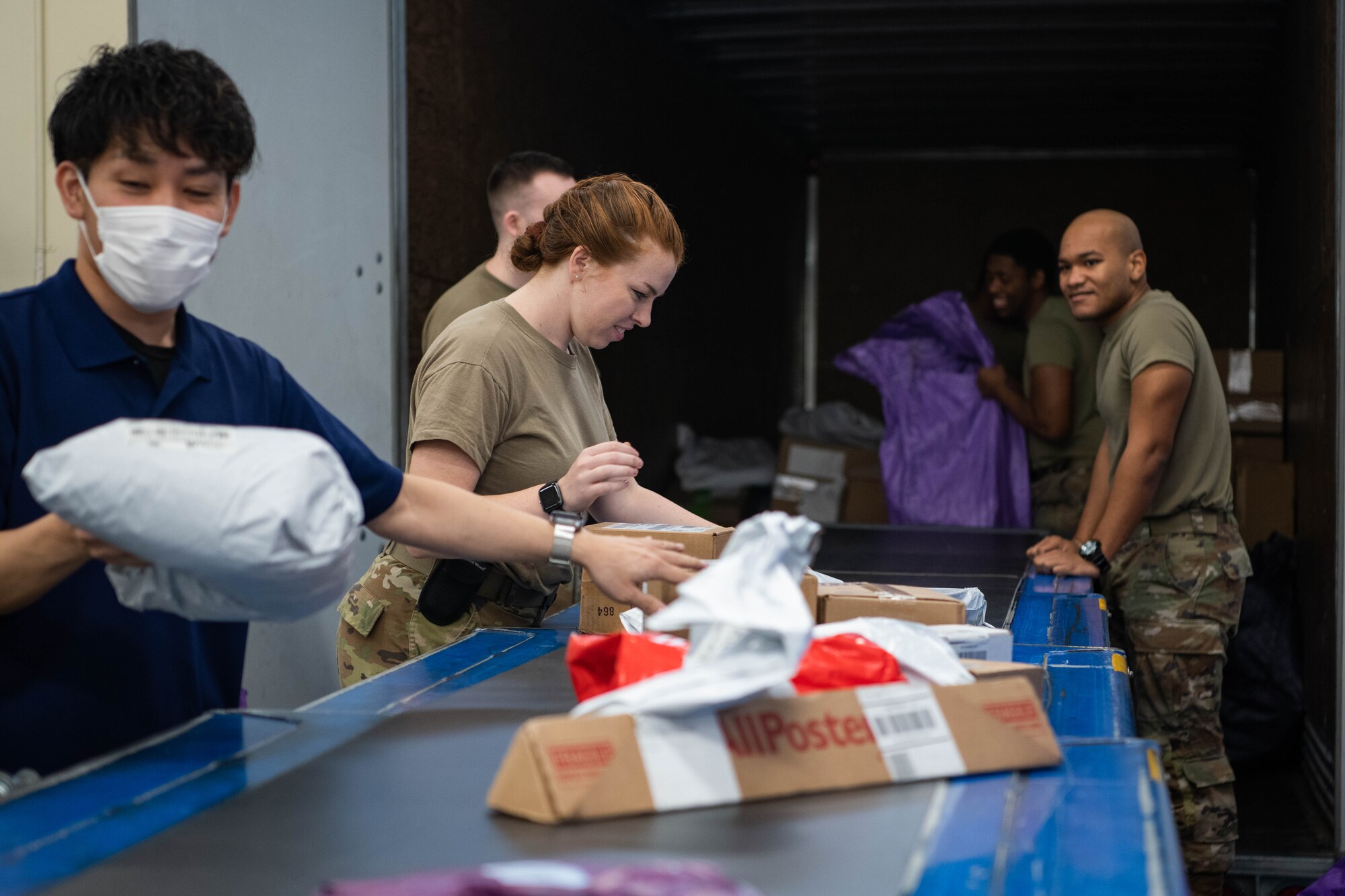 Airmen sort mail.