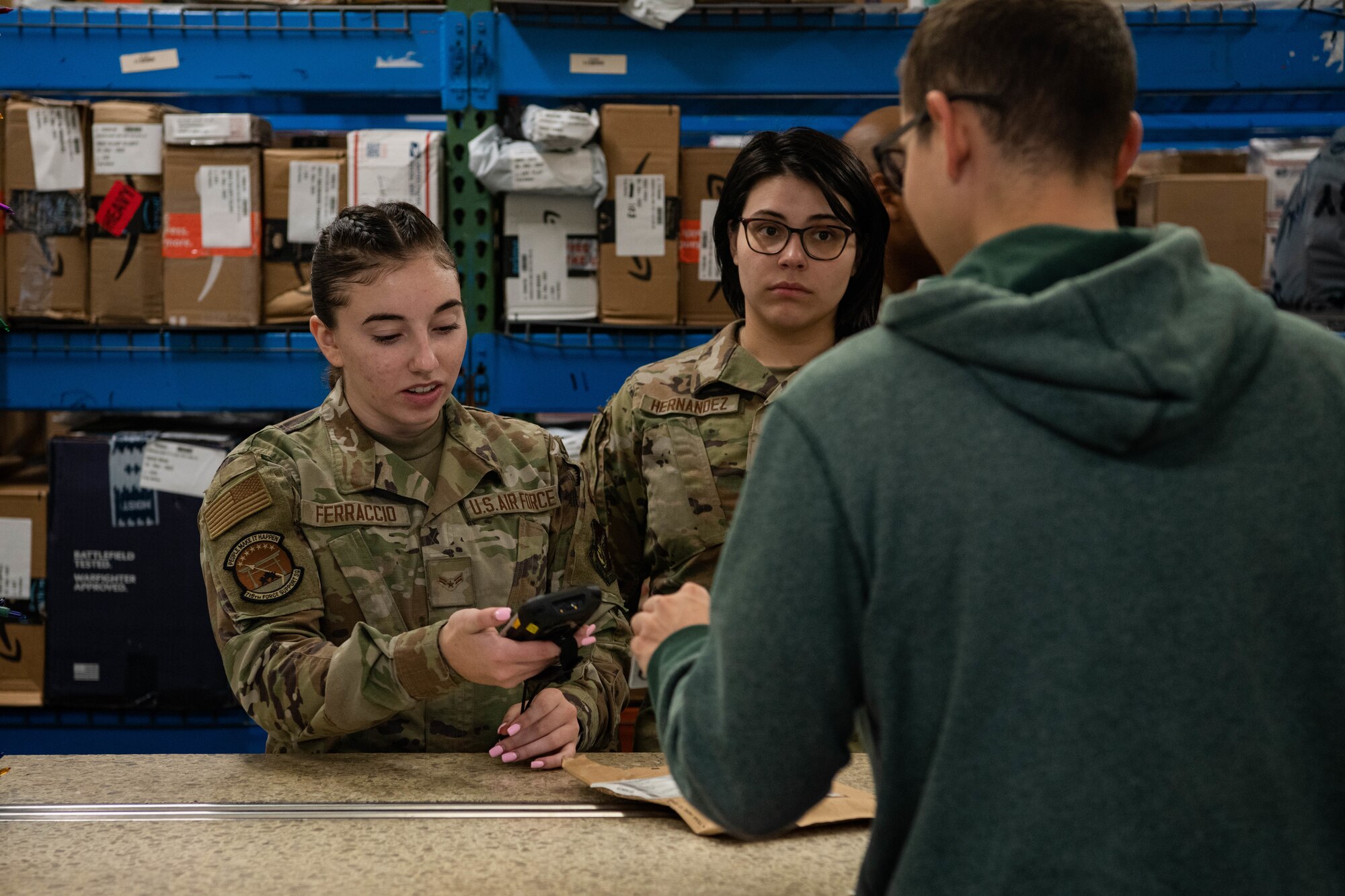 Postal Airmen assist a customer.